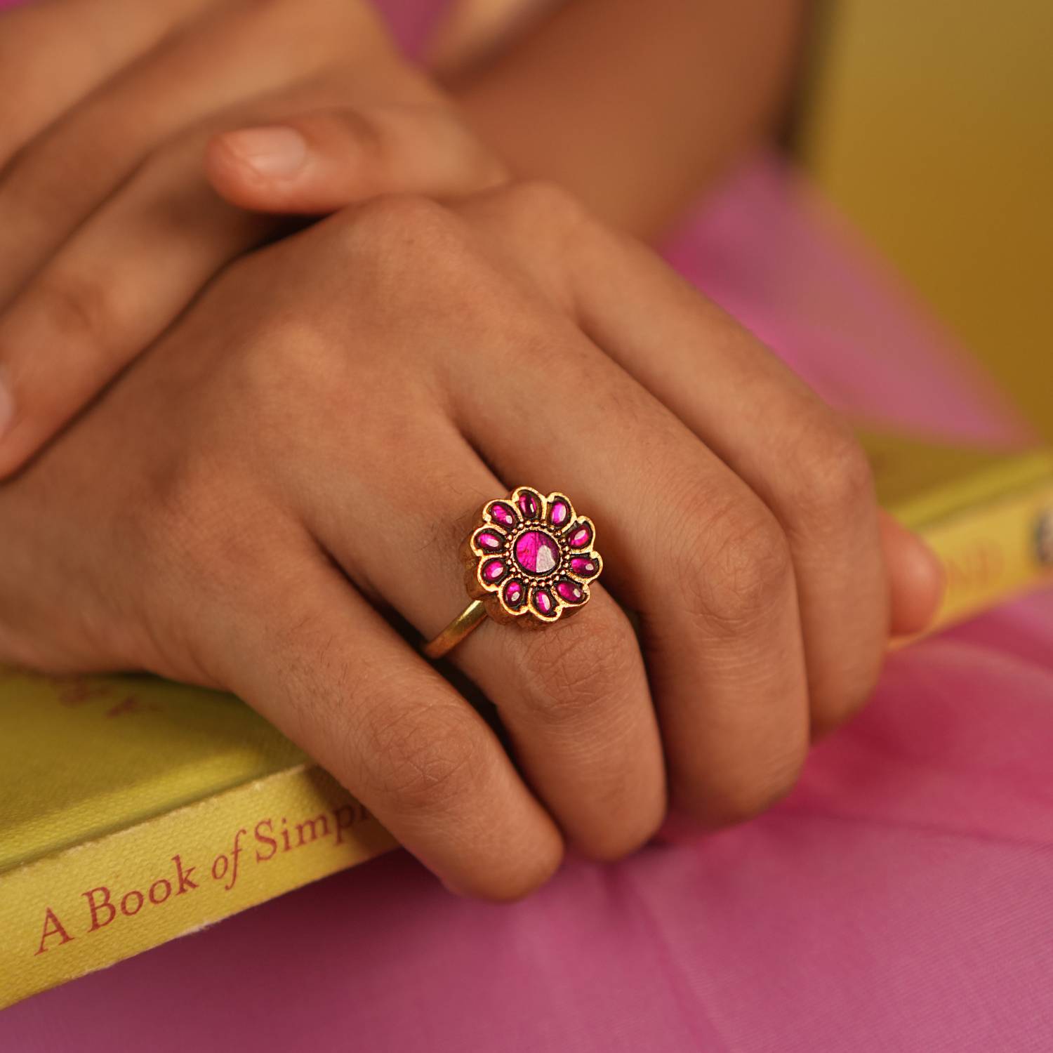 This floral-shaped ring, featuring a striking red Kundan stone, is meticulously handcrafted with unique asymmetrical variations that enhance its charm. A perfect fusion of traditional craftsmanship and contemporary elegance.