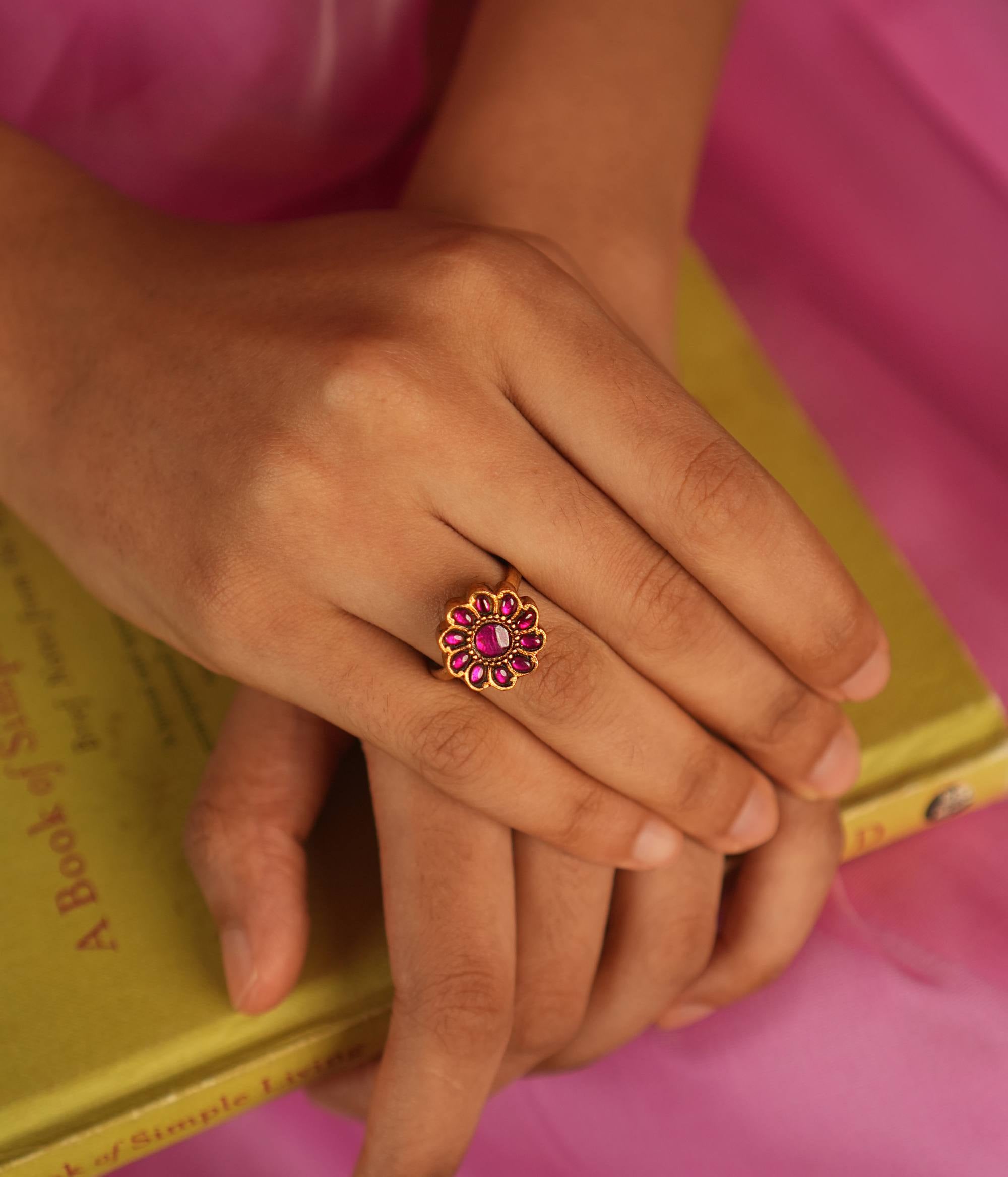 This floral-shaped ring, featuring a striking red Kundan stone, is meticulously handcrafted with unique asymmetrical variations that enhance its charm. A perfect fusion of traditional craftsmanship and contemporary elegance.