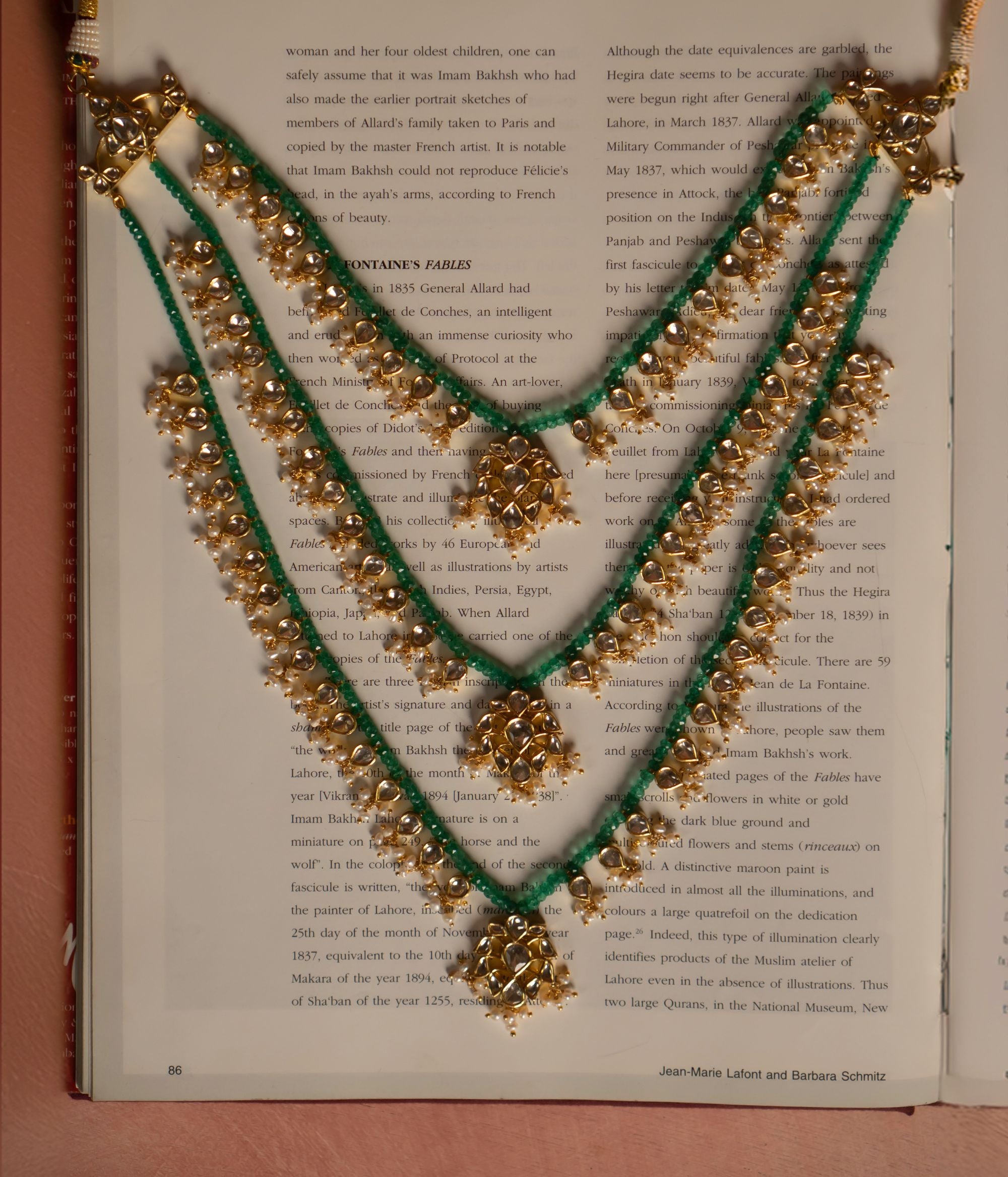 Elegant gold-plated silver necklace featuring layers of vibrant green beads intertwined with intricate white sapphires and pearl embellishments. The necklace showcases three floral-shaped pendants adorned with shimmering white sapphire stones, exuding a regal and traditional charm.