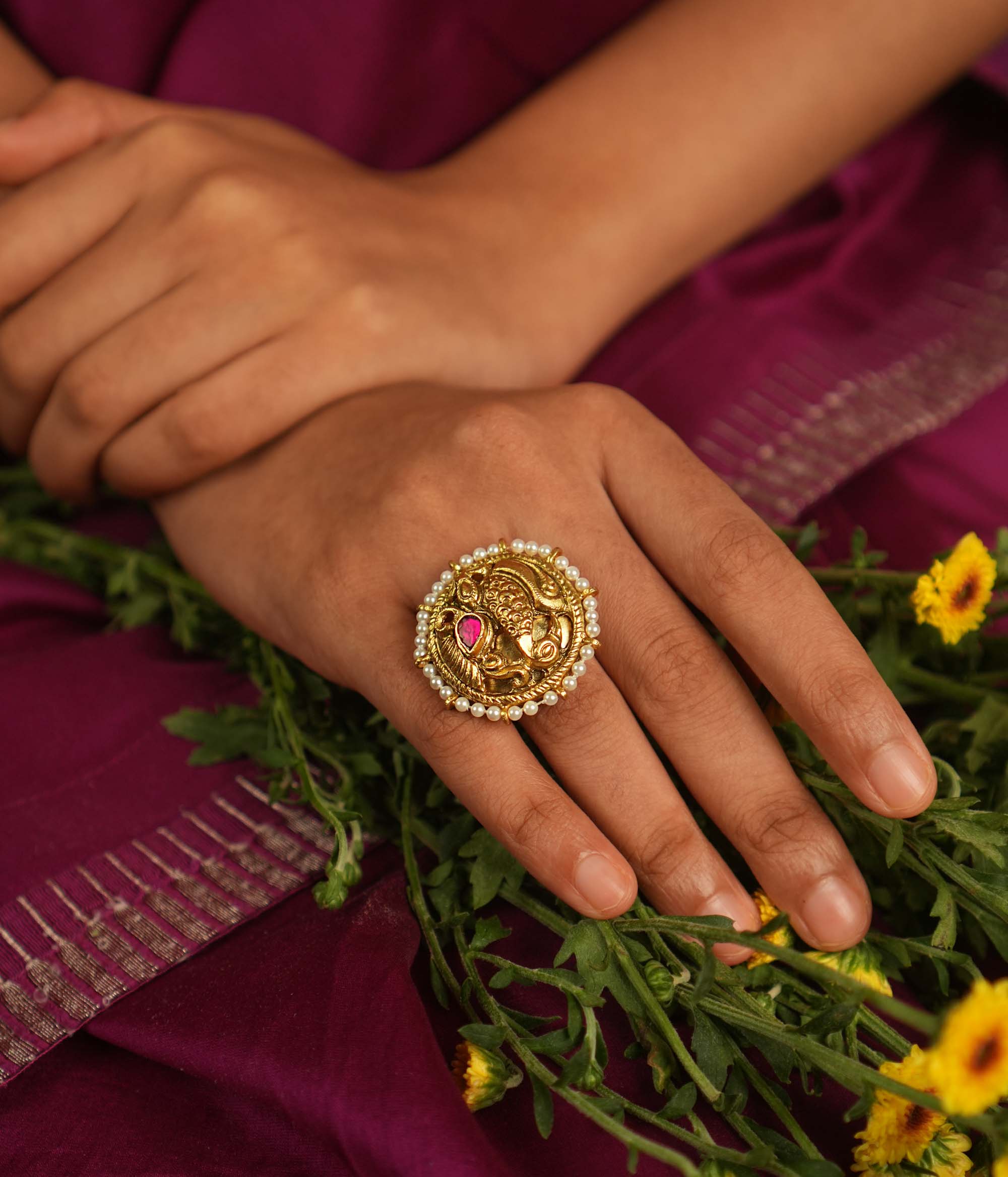 Adorn your finger with this exquisite gold-plated ring, featuring a captivating peacock motif, adorned with radiant red and white Kundan stones. The intricate feathers and Basra pearls add a touch of divine elegance, making this ring a timeless piece of craftsmanship.