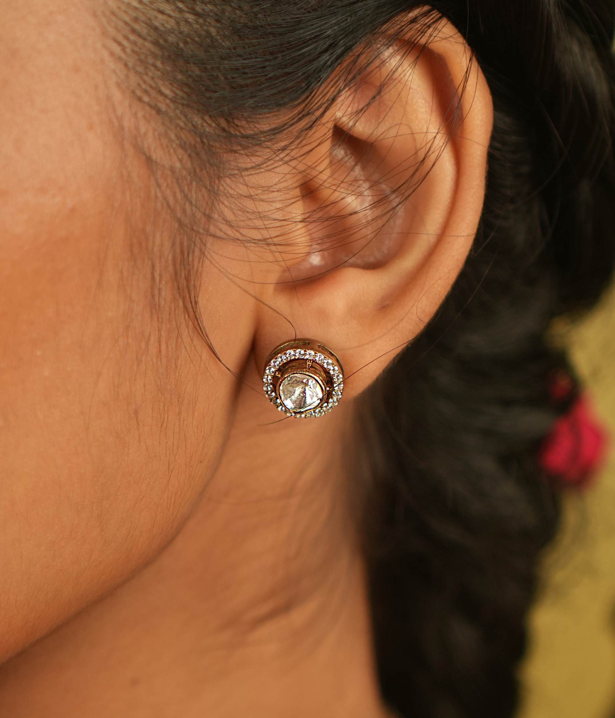 A pair of minimal round Polki stud earrings, framed by shimmering Moissanite stones, radiates refined elegance and contemporary sophistication.