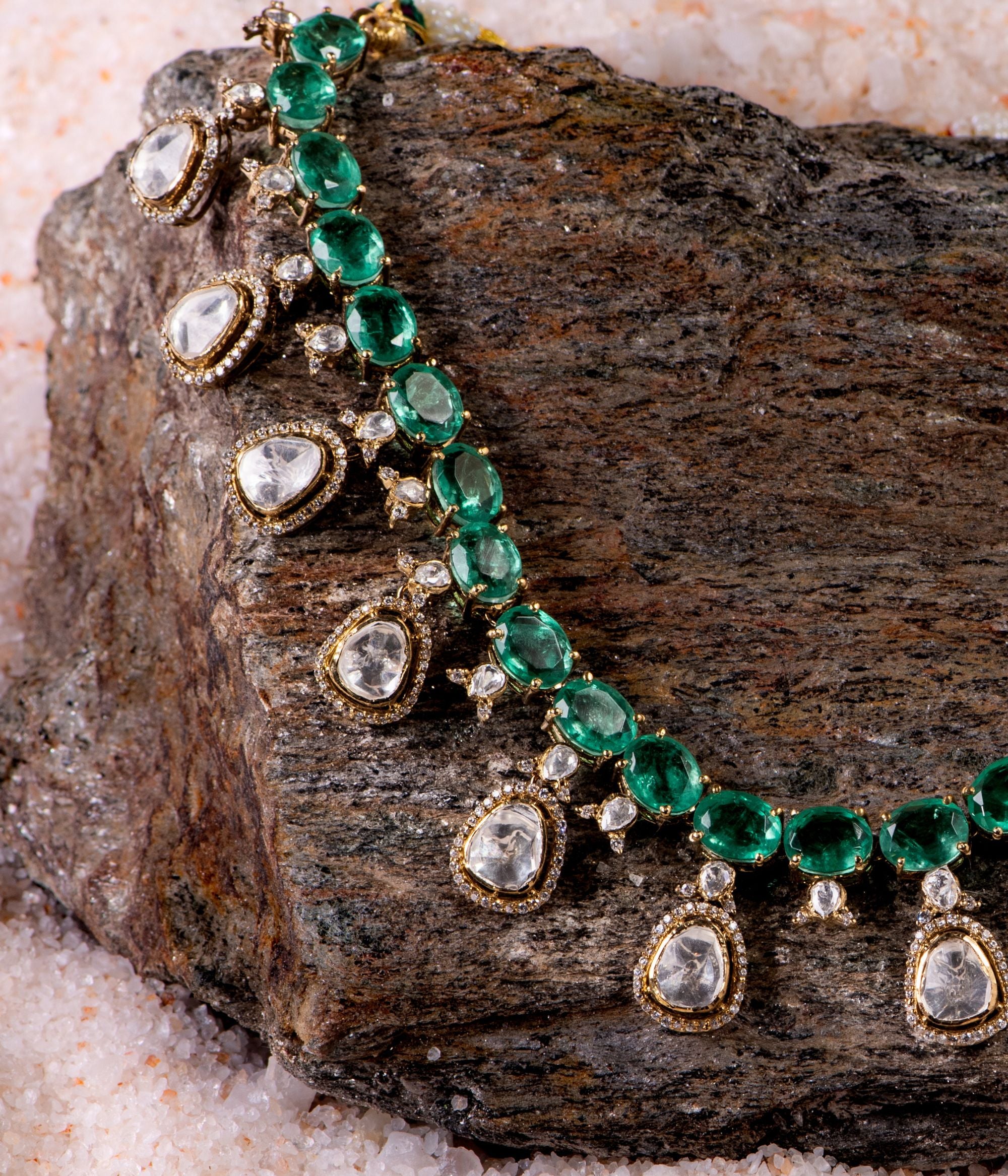 Gold-plated silver necklace featuring a continuous chain of vibrant green gemstones, elegantly adorned with Moissanite Polki stone drops, each surrounded by shimmering CZ stones. This exquisite design exudes grace and sophistication, making it a timeless statement piece.