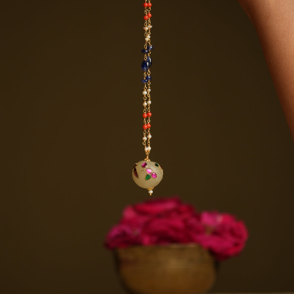 A minimal 92.5 sterling silver necklace featuring a natural off-white stone intricately engraved with a pink Kundan meenakari bird motif, inspired by vintage Rajput design, exuding ethereal elegance and subtle luxury.