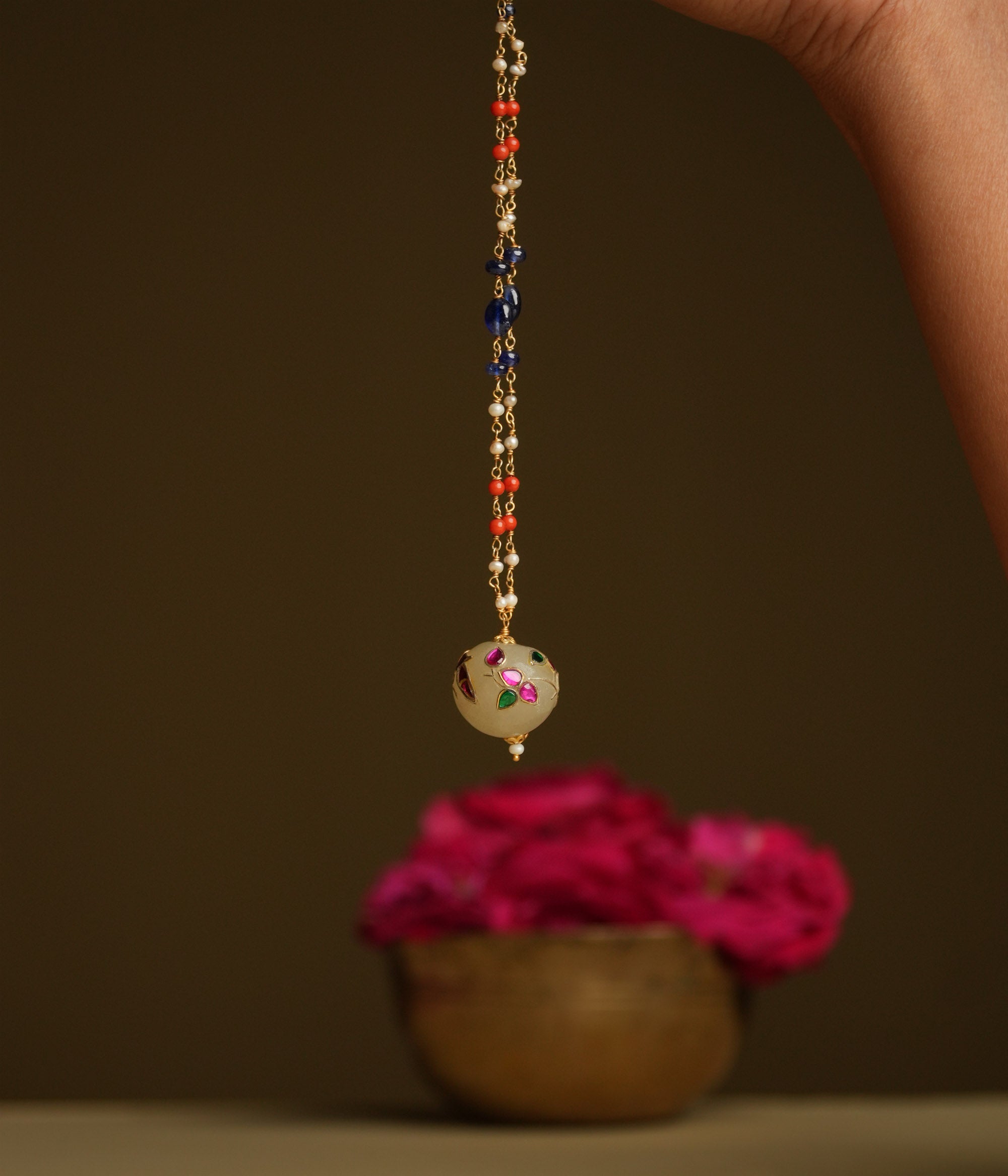 A minimal 92.5 sterling silver necklace featuring a natural off-white stone intricately engraved with a pink Kundan meenakari bird motif, inspired by vintage Rajput design, exuding ethereal elegance and subtle luxury.