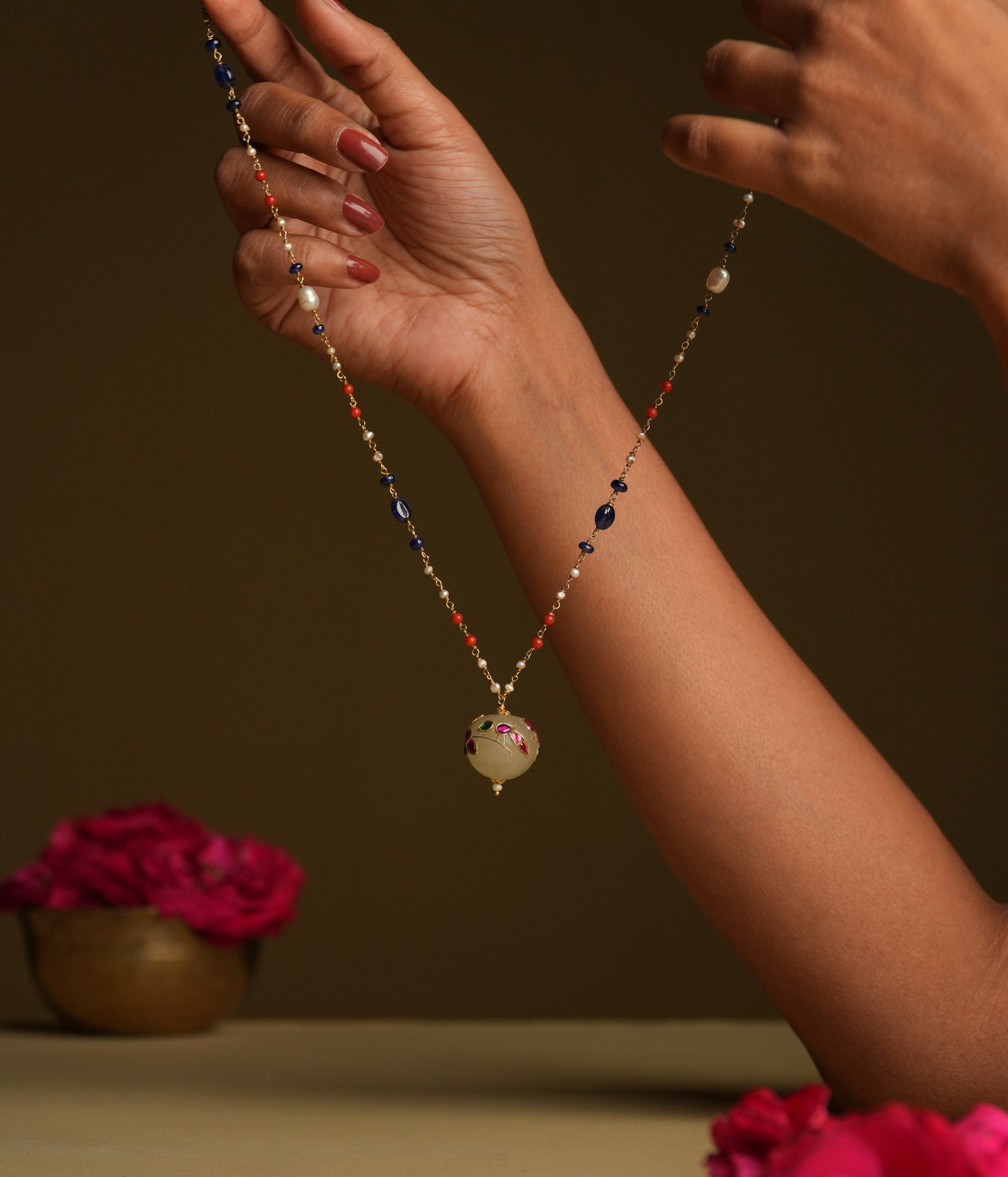 A minimal 92.5 sterling silver necklace featuring a natural off-white stone intricately engraved with a pink Kundan meenakari bird motif, inspired by vintage Rajput design, exuding ethereal elegance and subtle luxury.