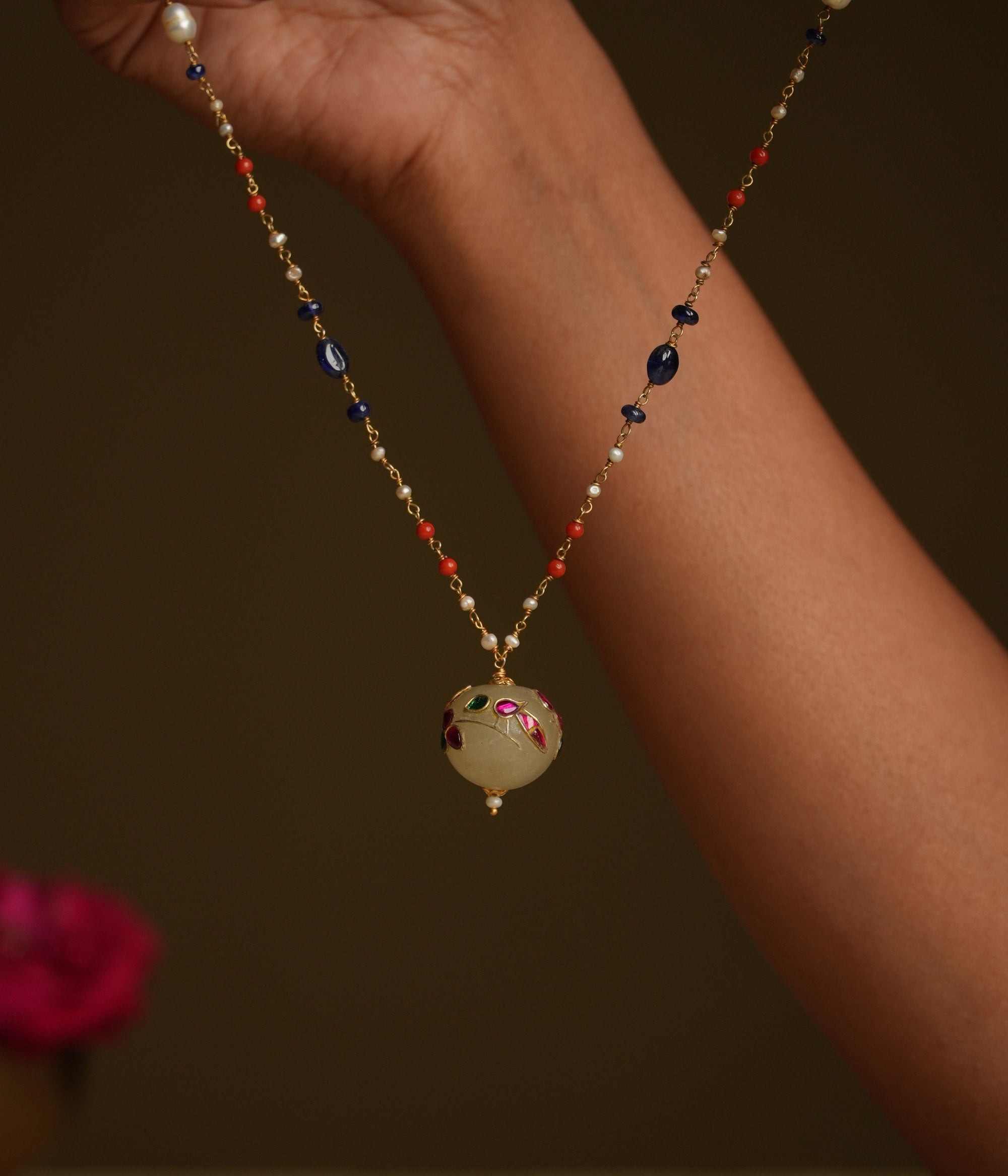 A minimal 92.5 sterling silver necklace featuring a natural off-white stone intricately engraved with a pink Kundan meenakari bird motif, inspired by vintage Rajput design, exuding ethereal elegance and subtle luxury.