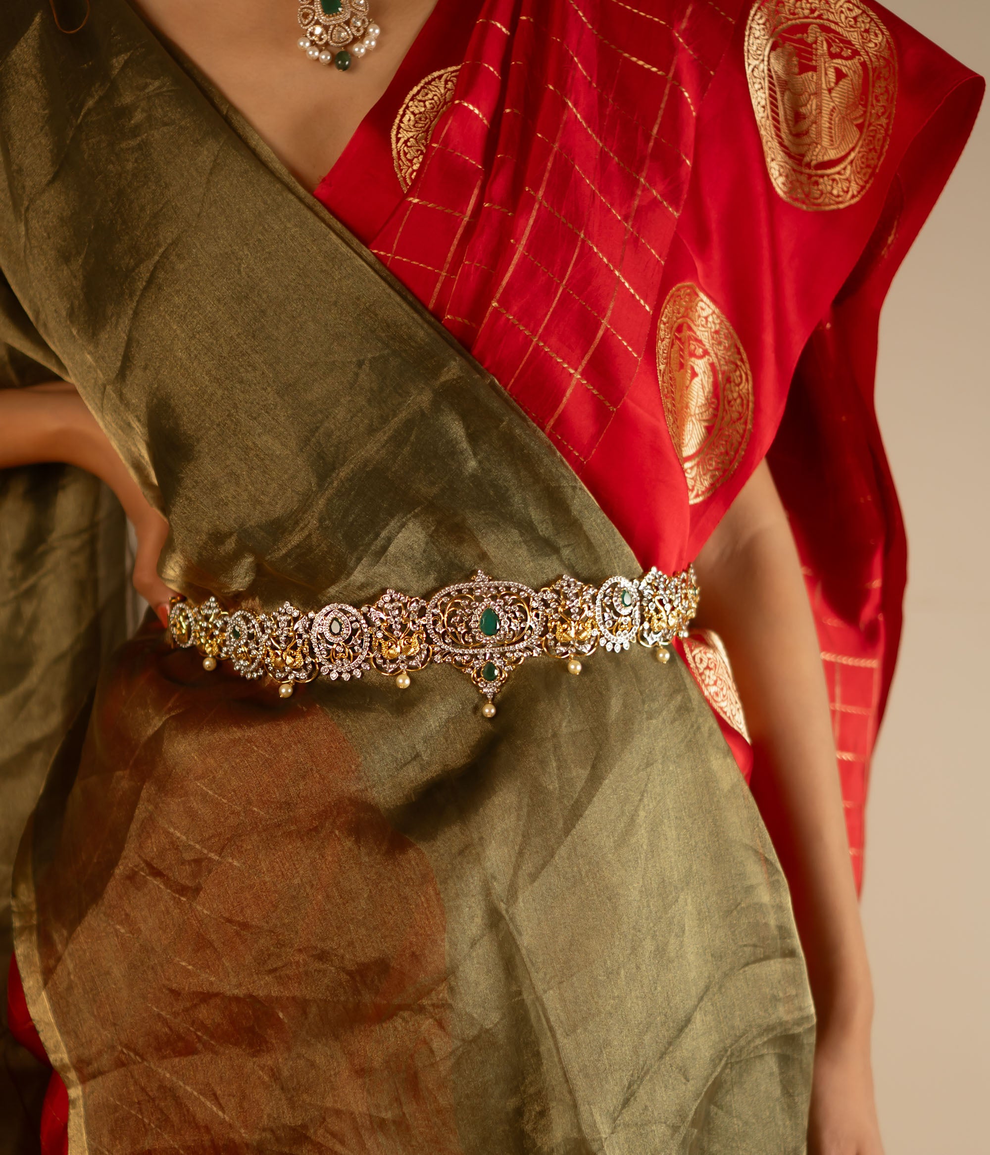 This hip belt is adorned with radiant green spinel stones, lustrous pearls, and sparkling CZ stones. Designed in a Victorian-inspired floral pattern, it showcases a mesmerizing blend of kundans and moissanite, exuding timeless elegance.