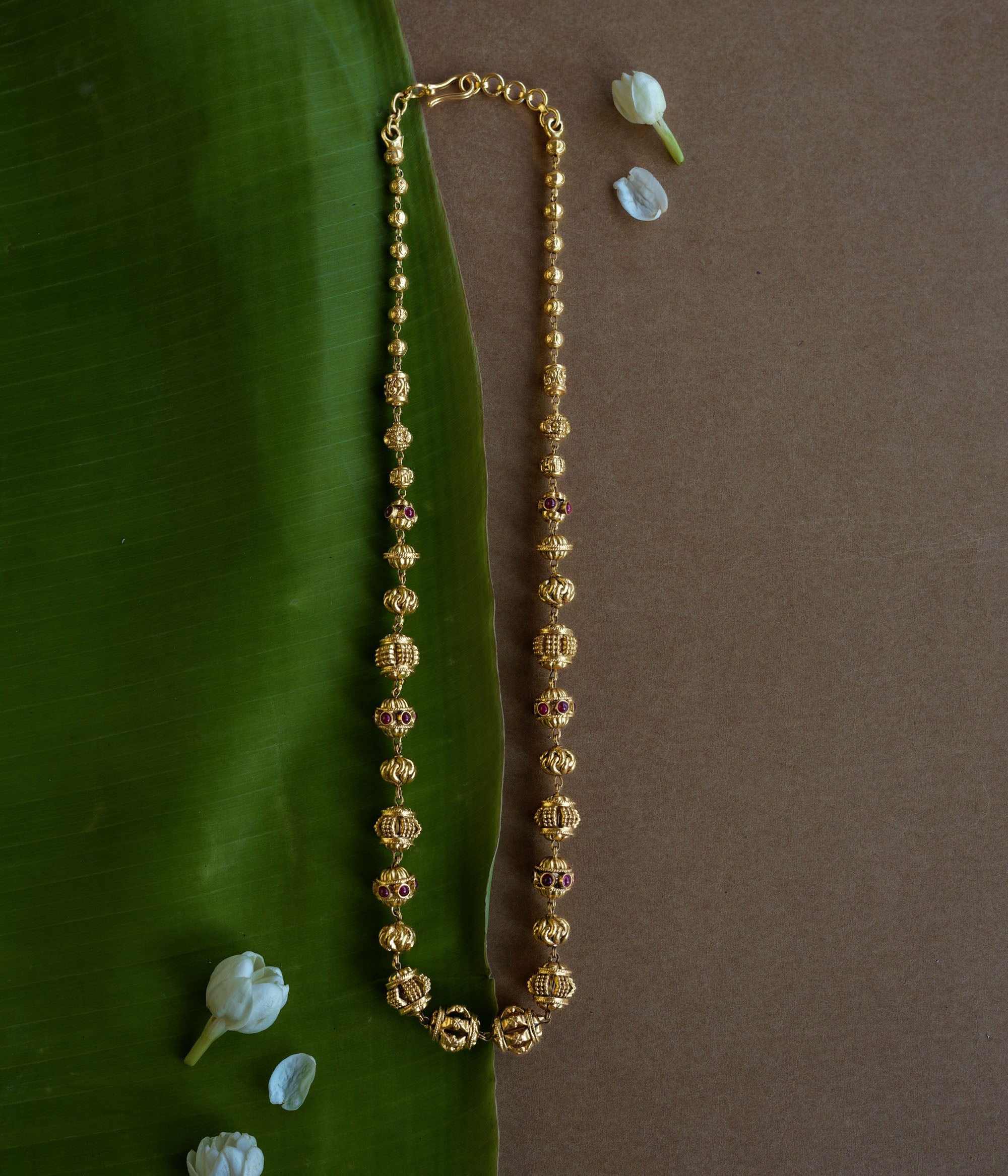Golden beaded chain with ornate spherical motifs and red spinel accents from the Plain Collection.