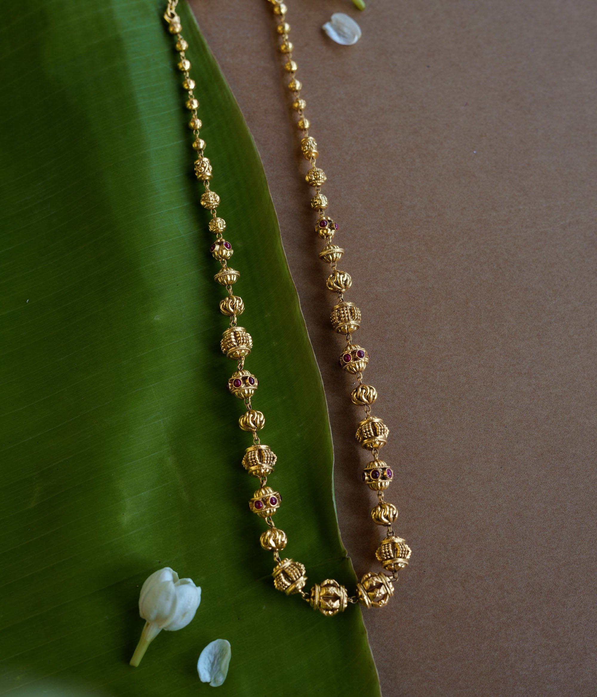 Golden beaded chain with ornate spherical motifs and red spinel accents from the Plain Collection.