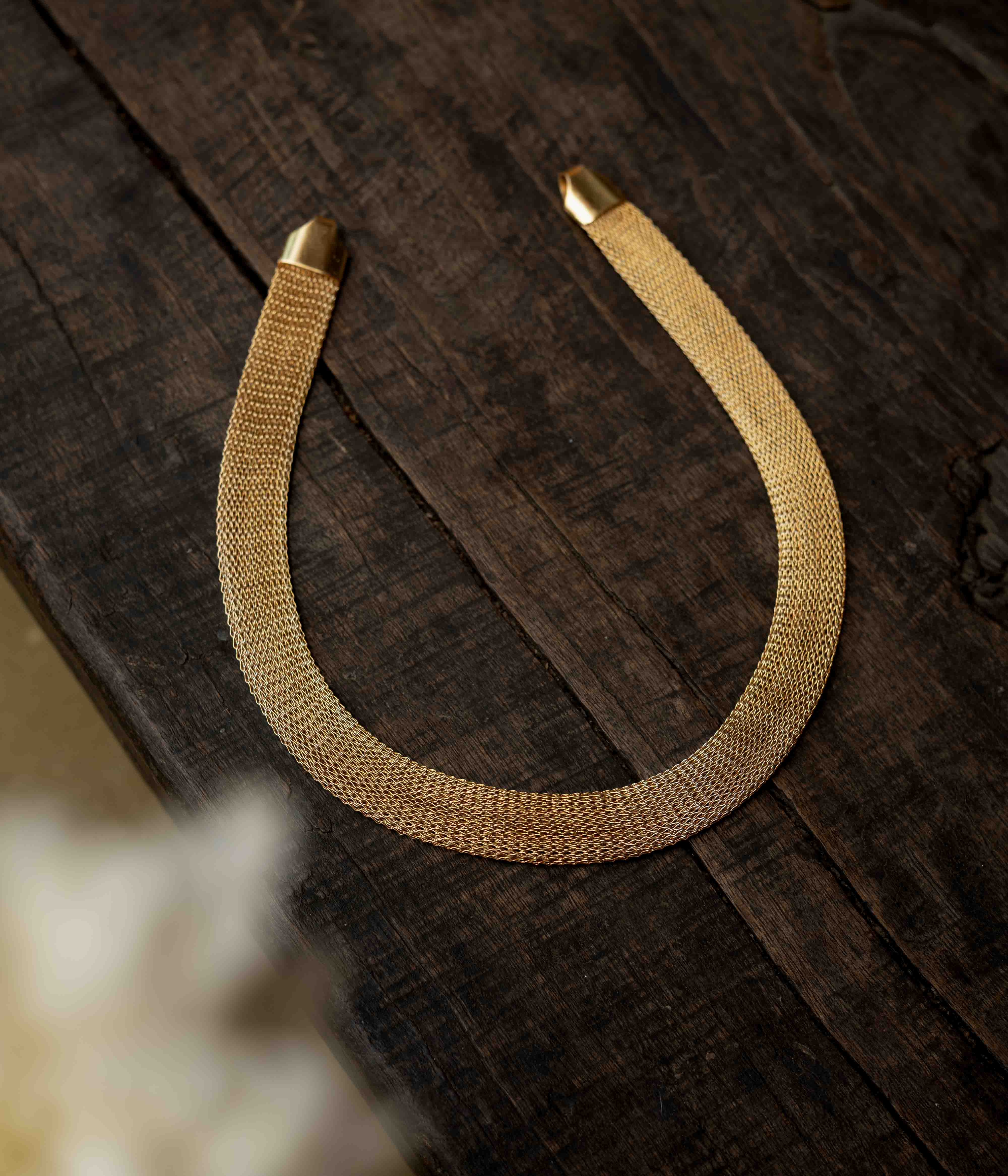 A multi-strand long chain made of small, gold-toned beads.