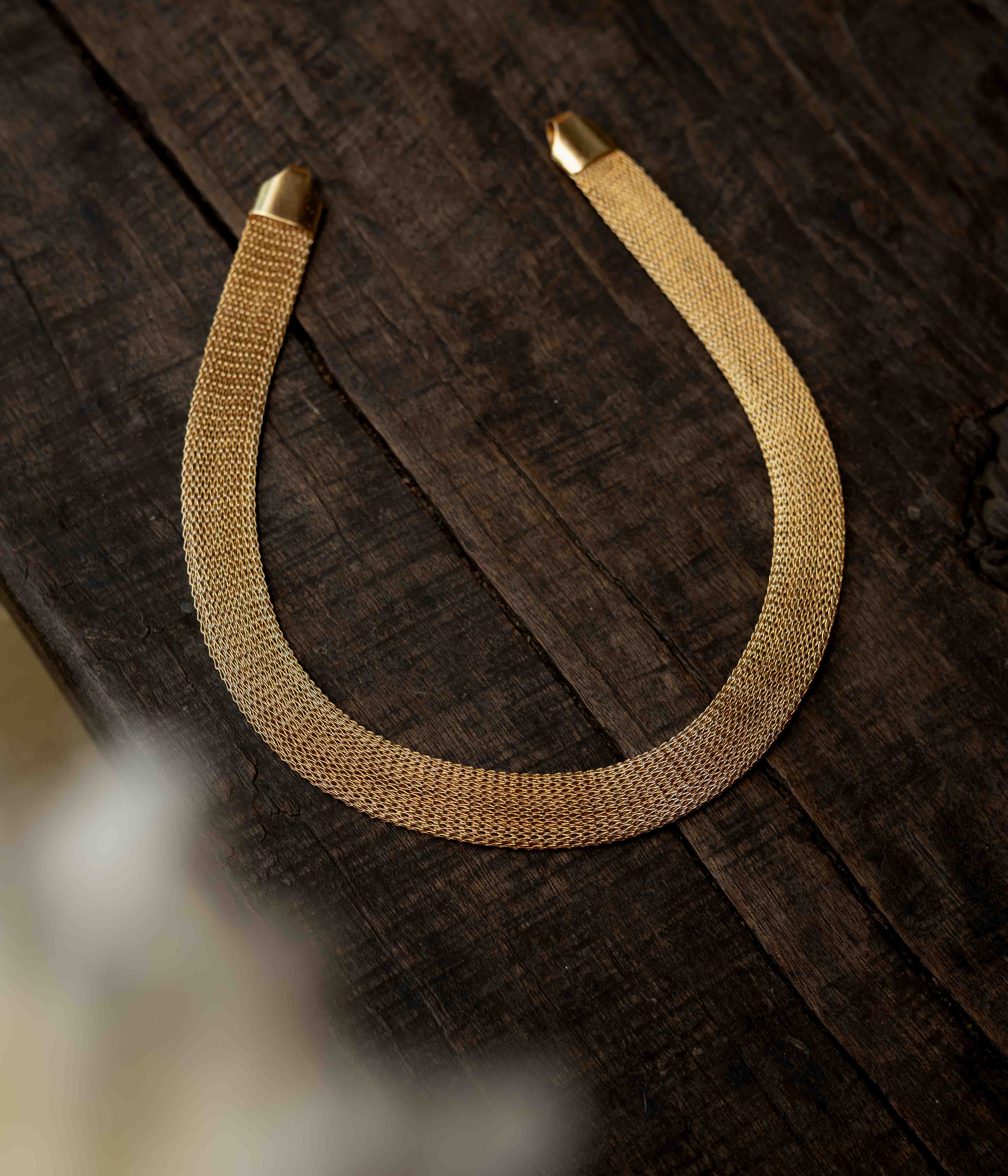 A multi-strand long chain made of small, gold-toned beads.