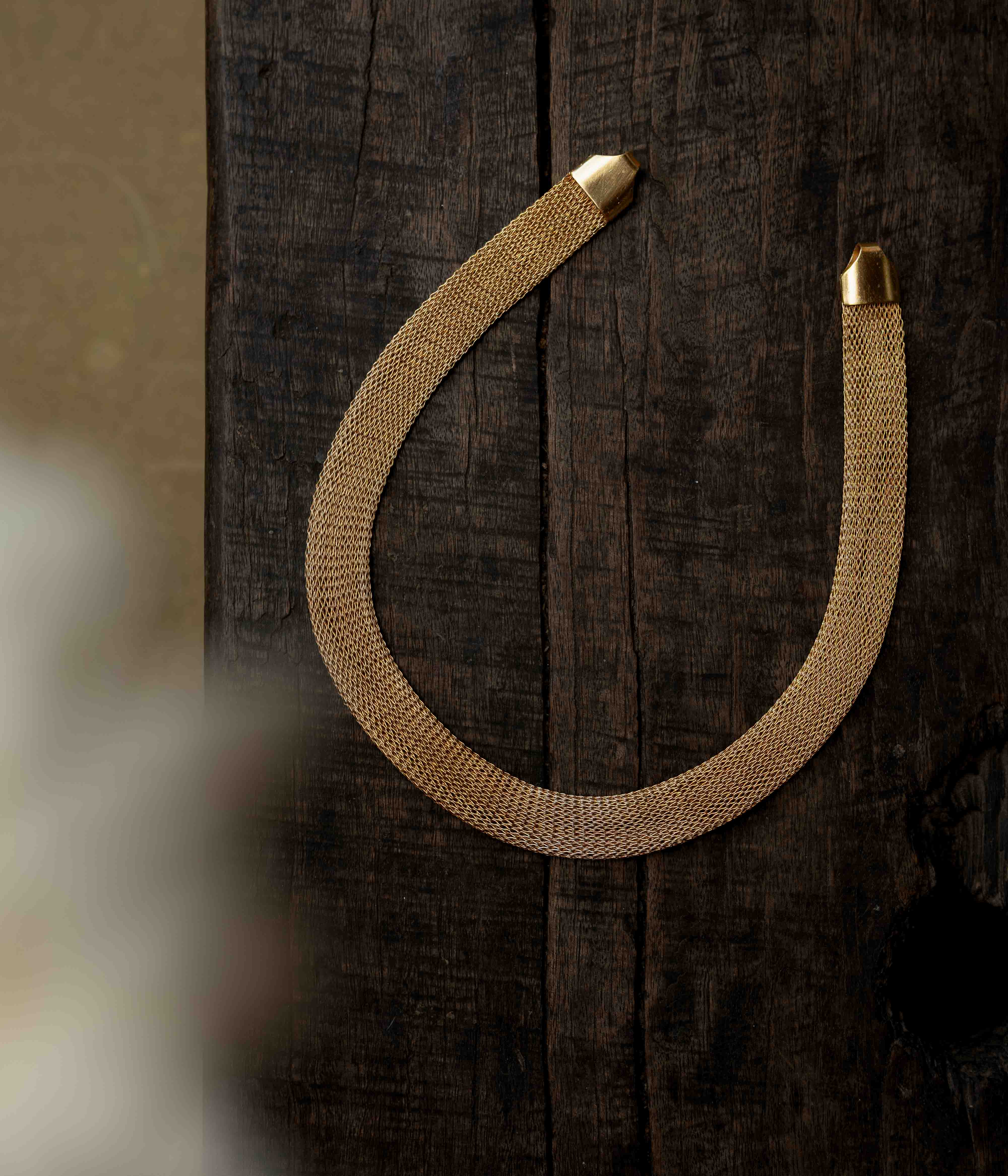 A multi-strand long chain made of small, gold-toned beads.