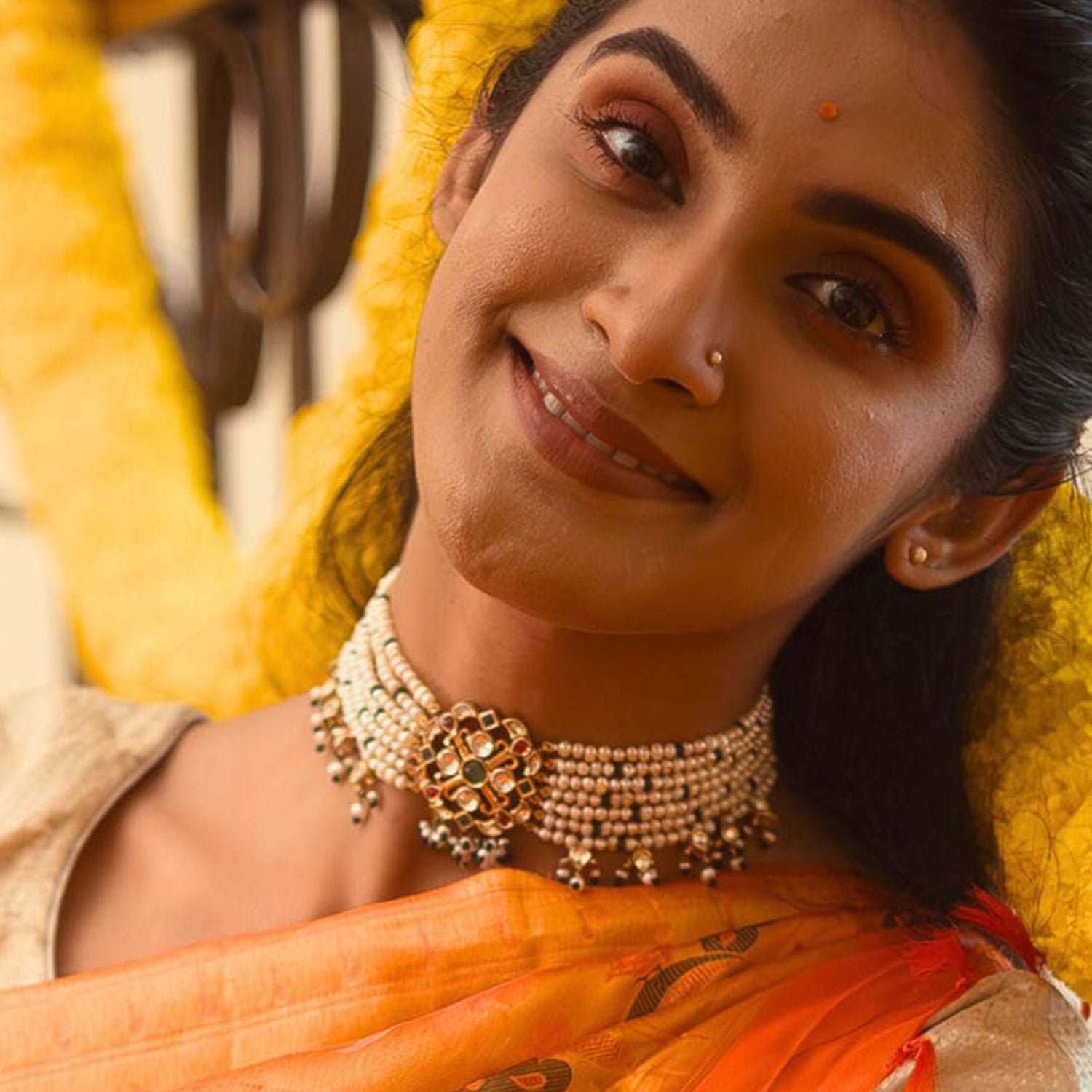 The Palash Choker weaves a symphony of sparkling white sapphires, rich rubies, emeralds, and luminous pearls, creating a masterpiece of timeless elegance and vibrant charm.