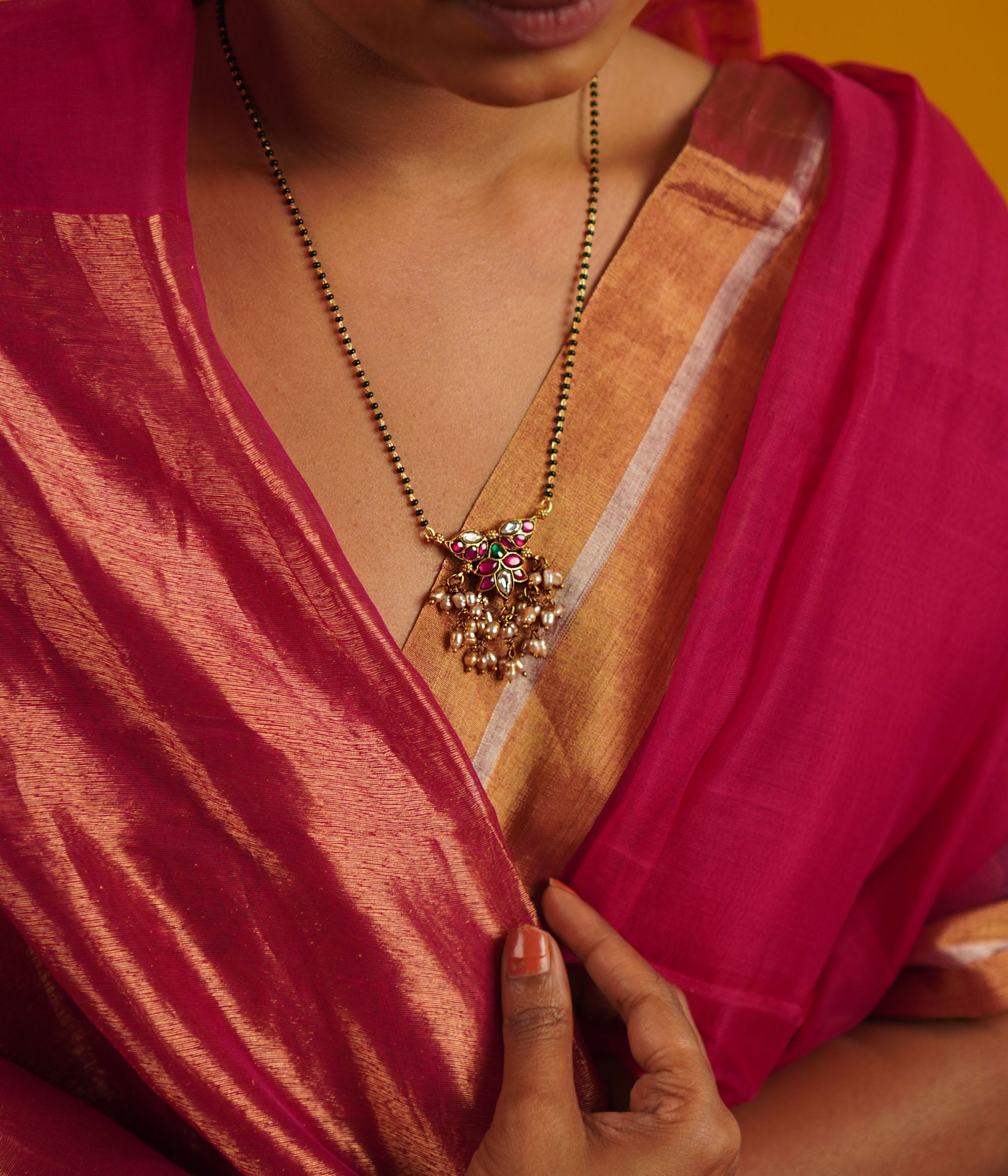 The Pansy Mangalsutra, crafted in gold-plated silver with radiant kundan stones and delicate pearl drops, seamlessly merges tradition with contemporary elegance. A timeless piece that celebrates heritage with a modern touch.