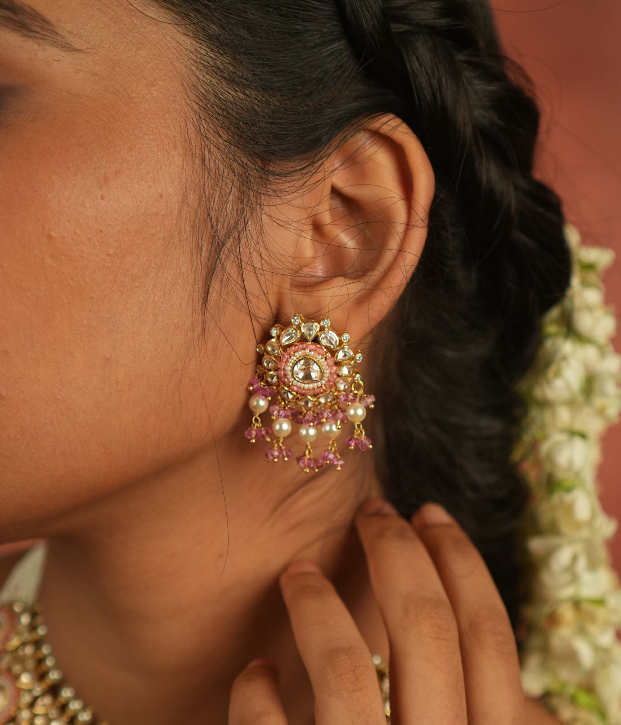 These exquisite dangler earrings, featuring Moissanite Polki stones, red beads, CZ stones, and pearls, offer a perfect balance of precision and elegance. Ideal for any occasion, they seamlessly complement both casual and formal attire.