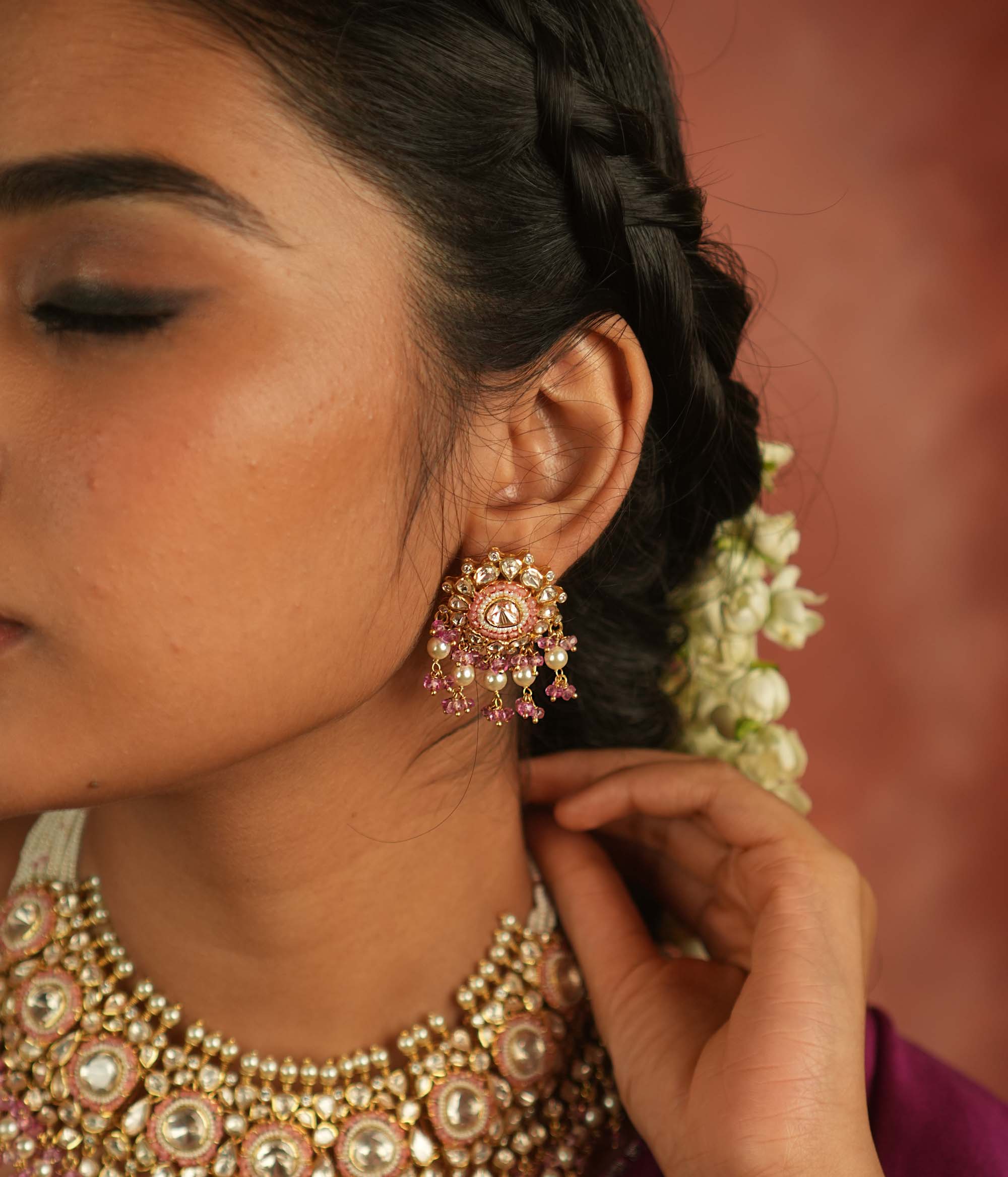 These exquisite dangler earrings, featuring Moissanite Polki stones, red beads, CZ stones, and pearls, offer a perfect balance of precision and elegance. Ideal for any occasion, they seamlessly complement both casual and formal attire.