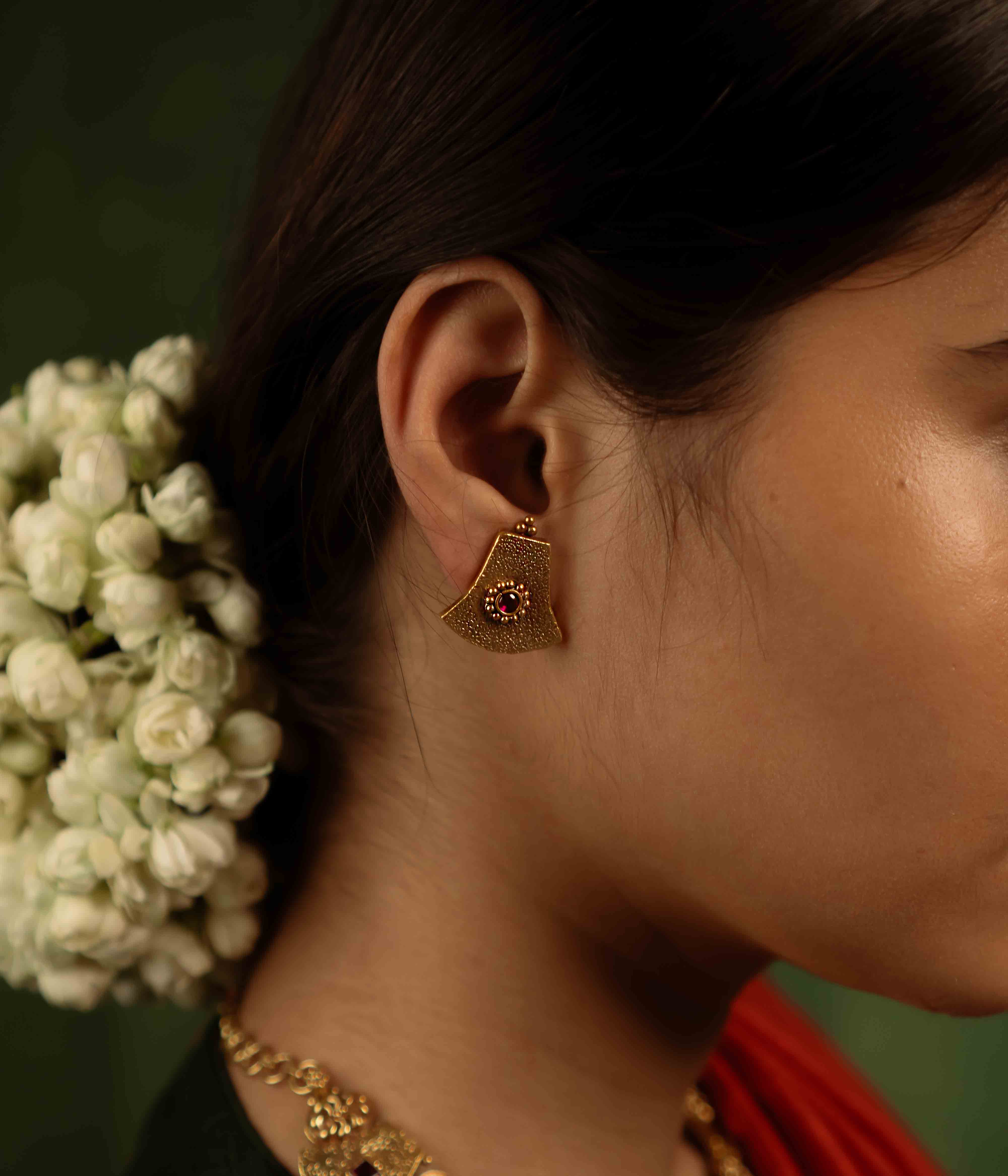 Ancient tales revived! The Peela-Kaner stud earrings (gold-plated silver) capture the essence of tribal heritage with their rich red spinel stones, delivering rustic elegance for the modern woman.