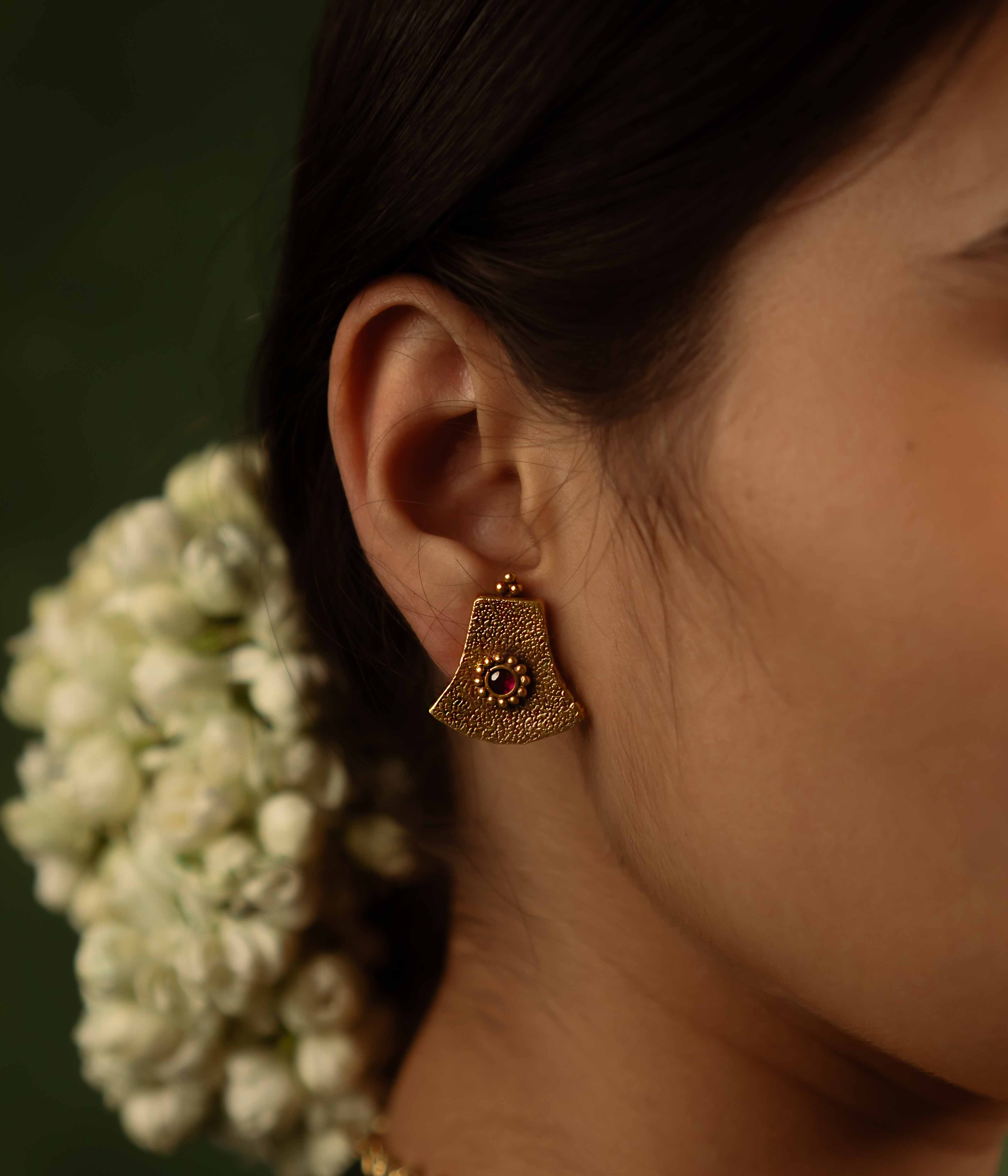 Ancient tales revived! The Peela-Kaner stud earrings (gold-plated silver) capture the essence of tribal heritage with their rich red spinel stones, delivering rustic elegance for the modern woman.