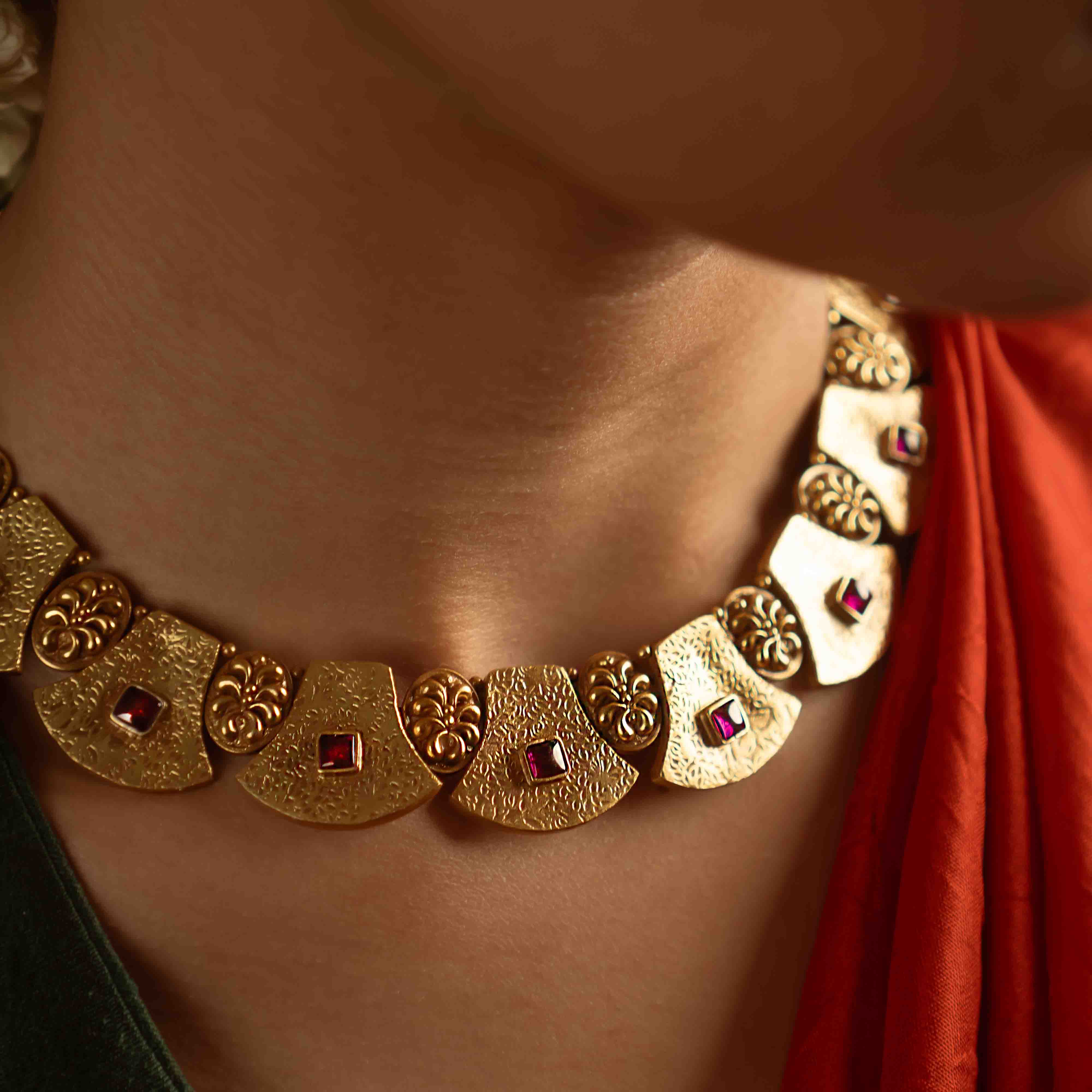 Ancient tales revived! The Peela-Kaner necklace (gold-plated silver) echoes tribal heritage with its rich red spinel stones, offering rustic elegance for the contemporary woman.