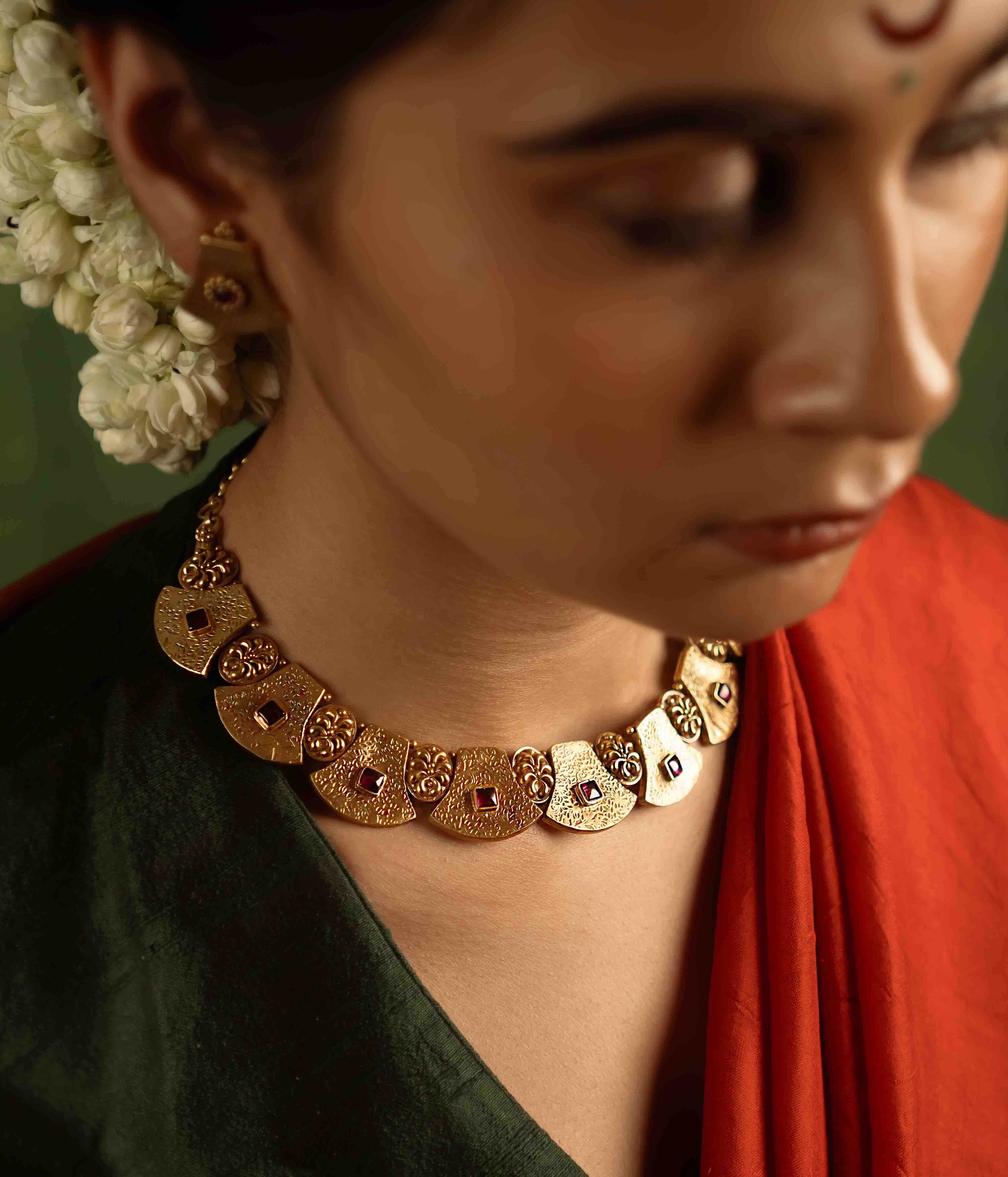 Ancient tales revived! The Peela-Kaner necklace (gold-plated silver) echoes tribal heritage with its rich red spinel stones, offering rustic elegance for the contemporary woman.