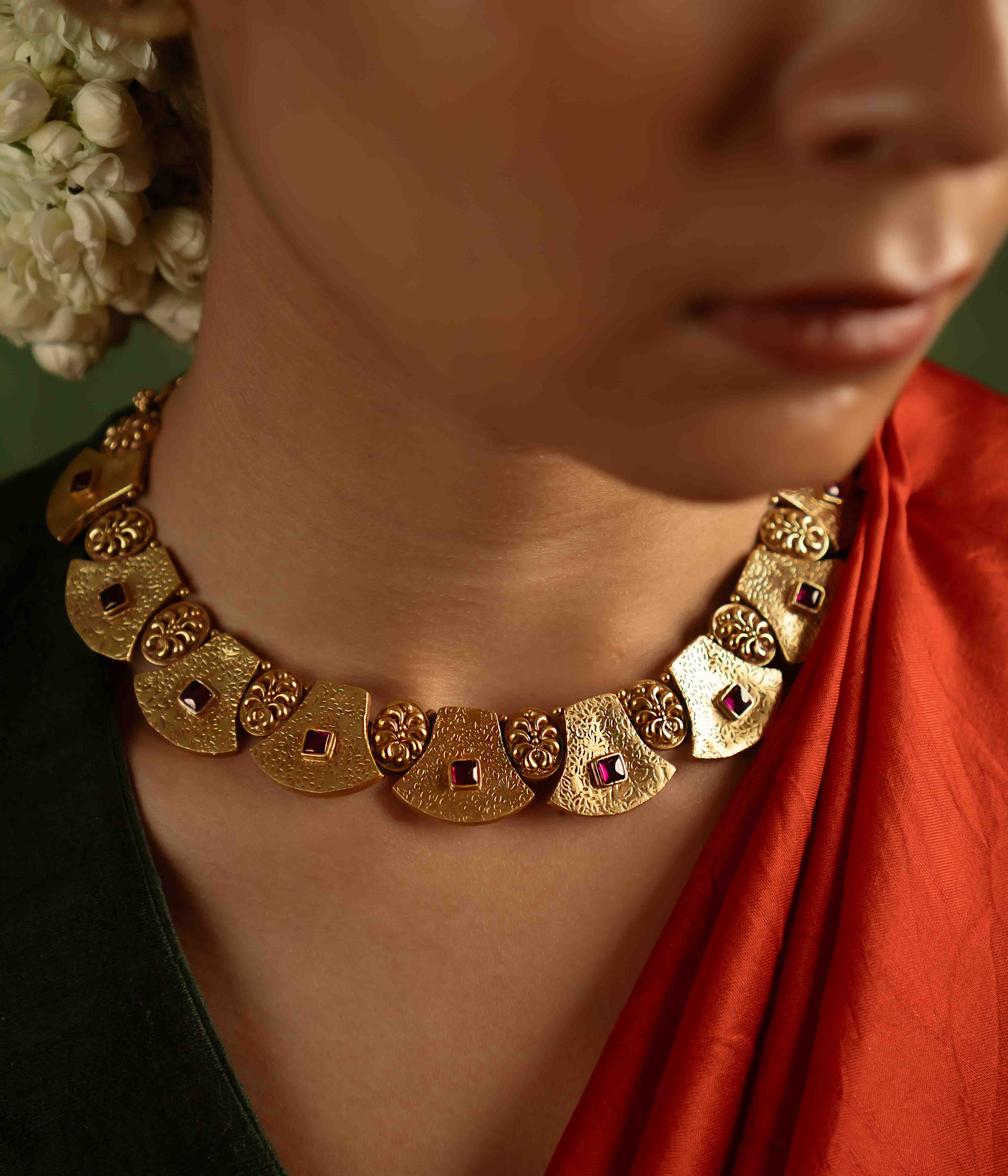 Ancient tales revived! The Peela-Kaner necklace (gold-plated silver) echoes tribal heritage with its rich red spinel stones, offering rustic elegance for the contemporary woman.
