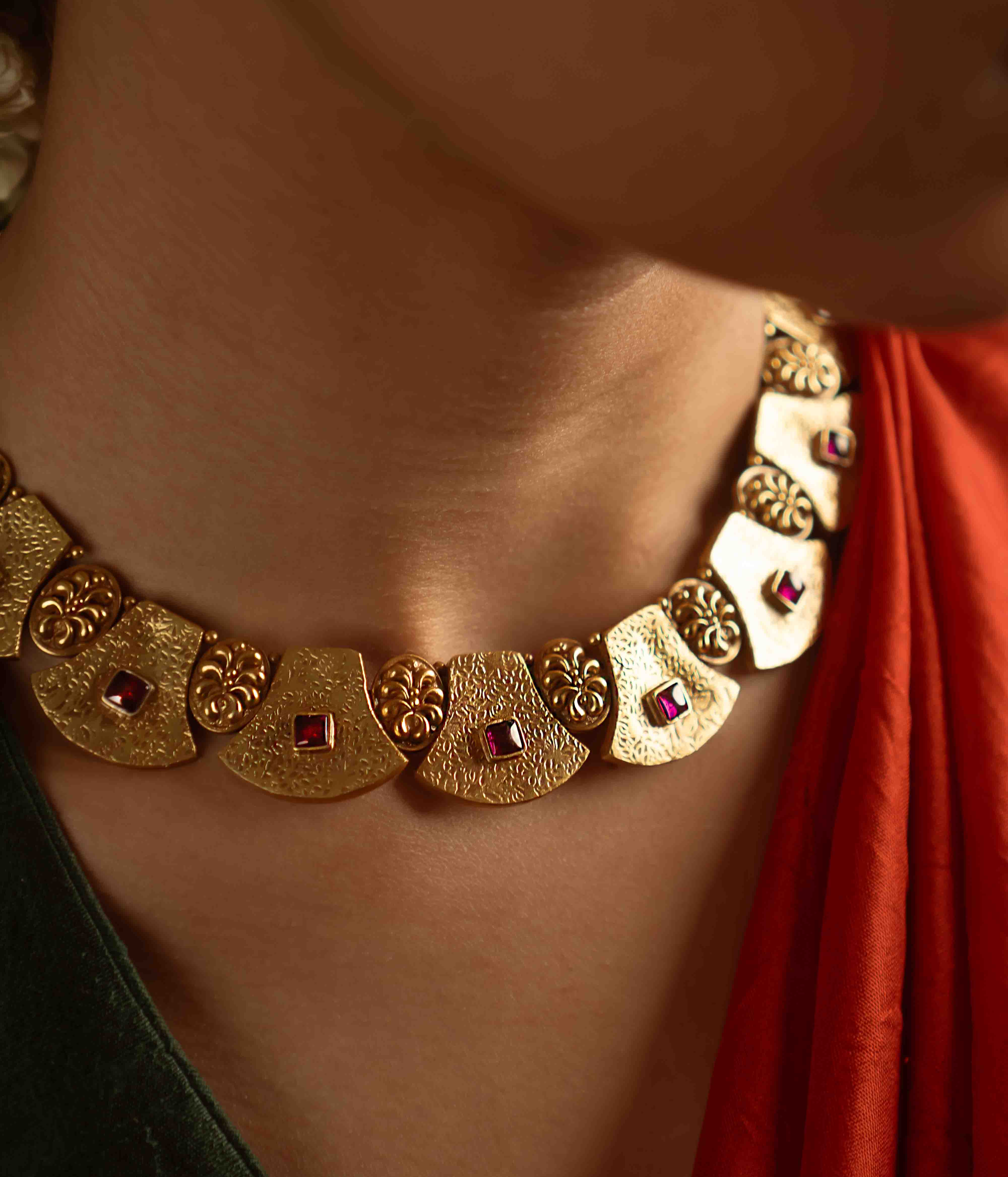 Ancient tales revived! The Peela-Kaner necklace (gold-plated silver) echoes tribal heritage with its rich red spinel stones, offering rustic elegance for the contemporary woman.