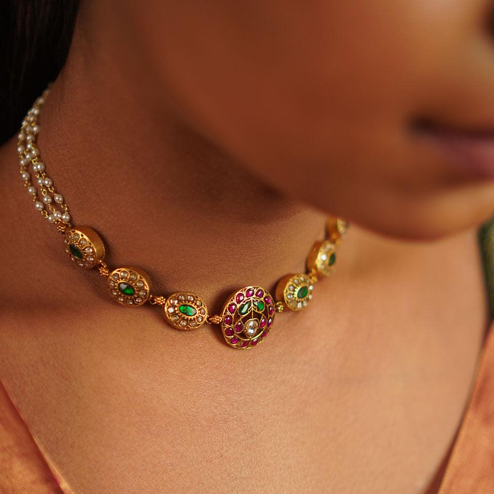 This antique silver choker, embellished with vibrant kundans, captures the delight of uncovering hidden treasures. A seamless fusion of tradition and charm, this piece embodies timeless elegance.