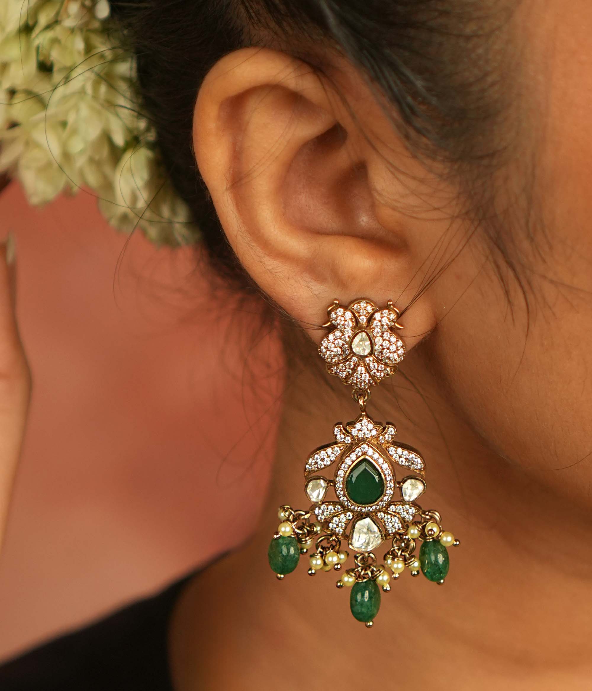 Victorian elegance reborn! Peacock-inspired dangler earrings with green gemstones, polki, and CZ stones, adorned with delicate green bead drops, echo timeless beauty and opulence.