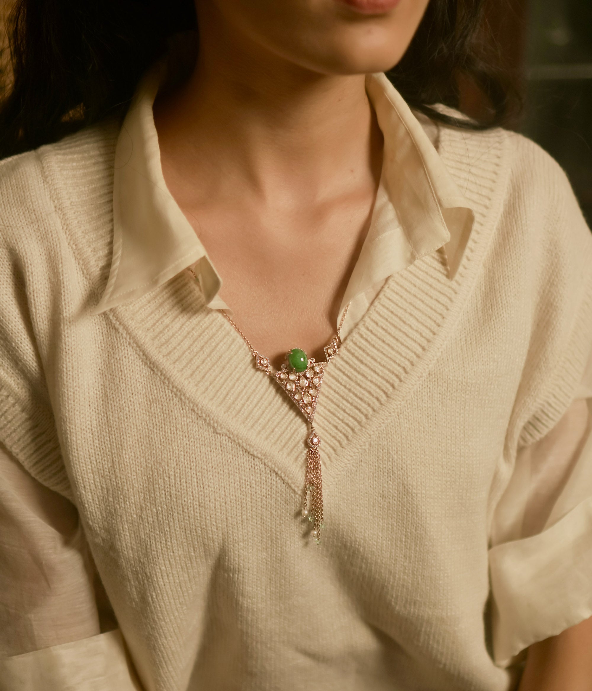 Triangular polki pendant chain with green gemstone, pearls, CZ accents, and tassel drop design.