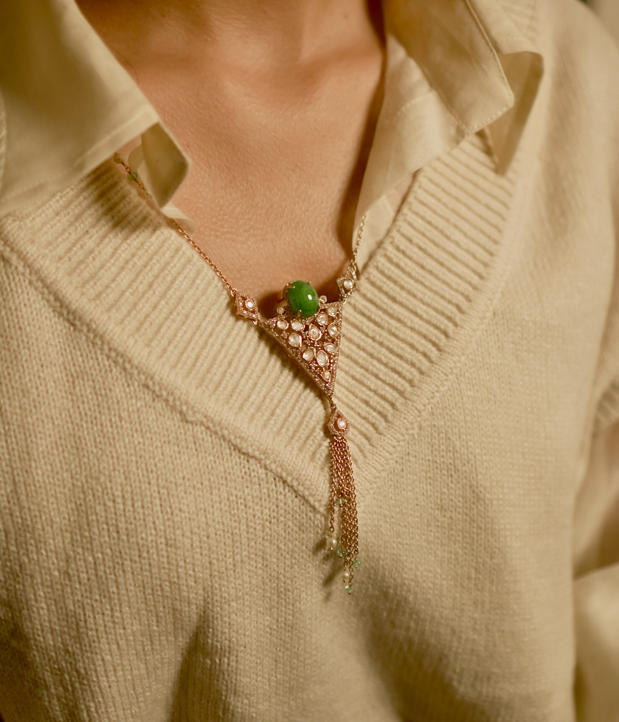 Triangular polki pendant chain with green gemstone, pearls, CZ accents, and tassel drop design.