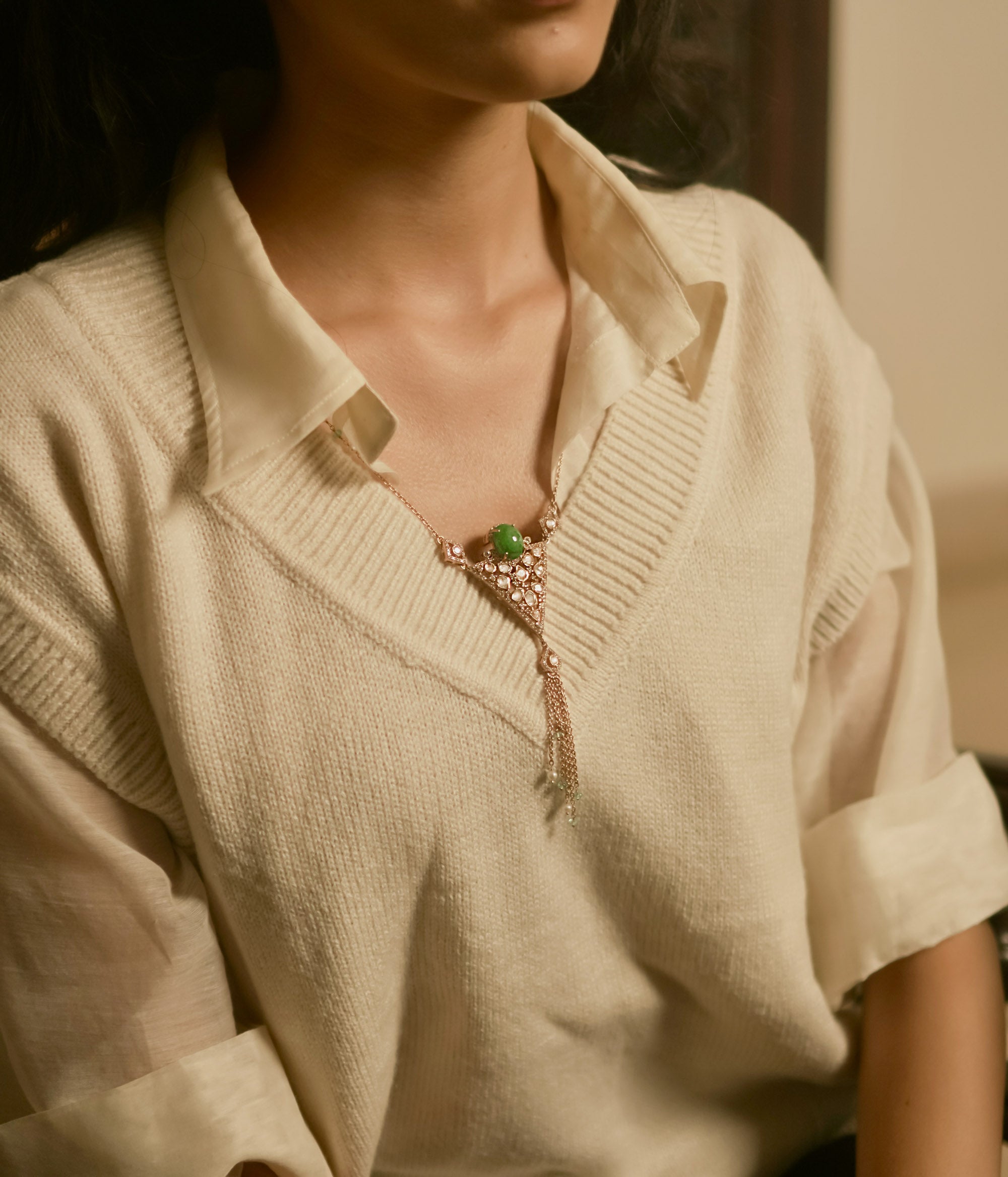 Triangular polki pendant chain with green gemstone, pearls, CZ accents, and tassel drop design.