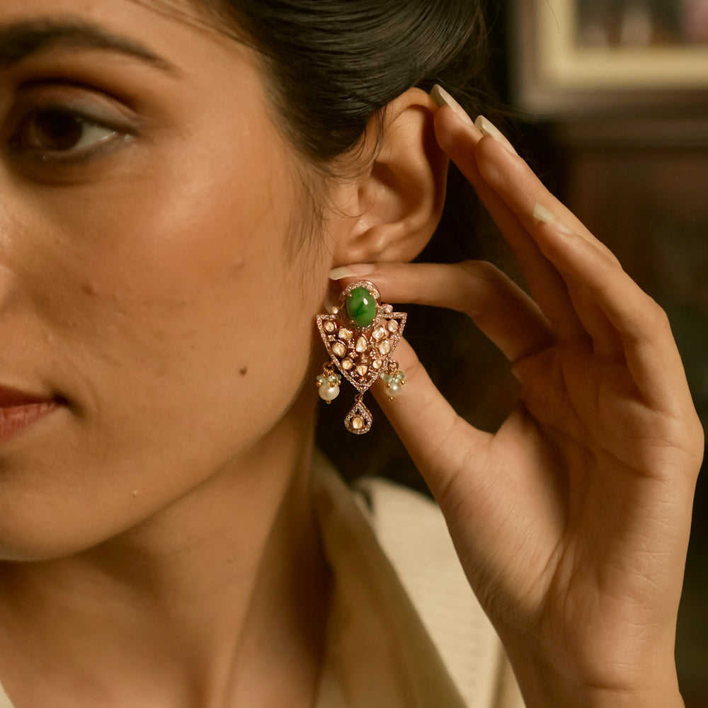 Triangular polki earrings with green gemstone, pearls, CZ accents, and tassel drop design.