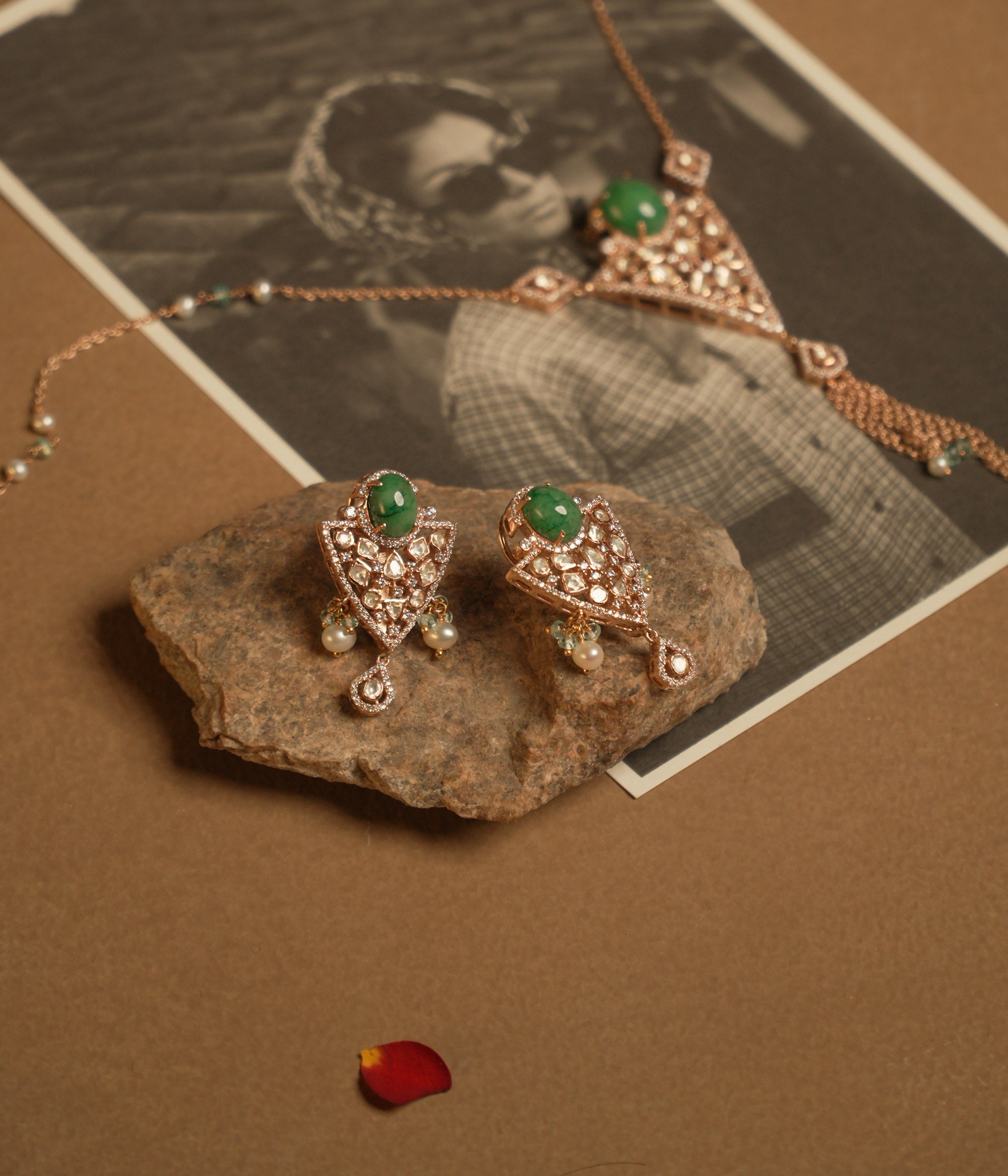 Triangular polki earrings with green gemstone, pearls, CZ accents, and tassel drop design.