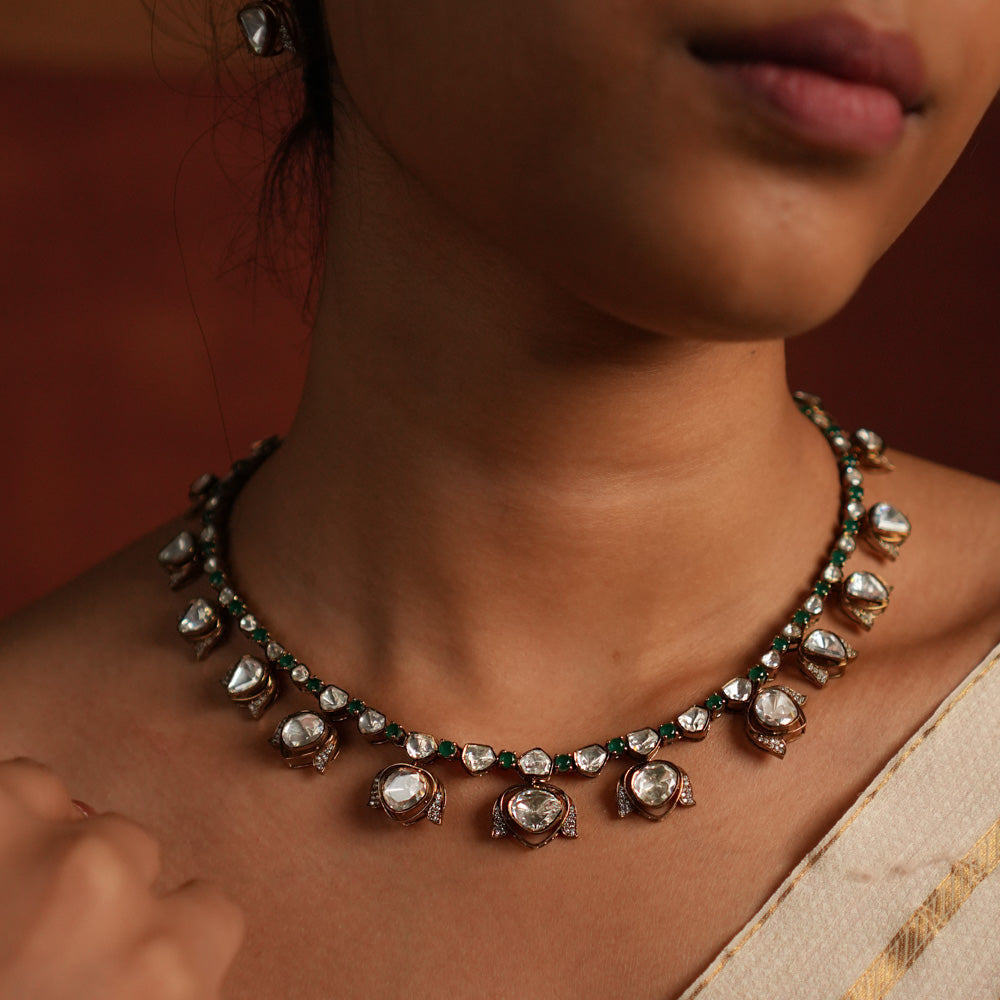 Elegant gold-plated silver drop necklace featuring a striking green spinel stone at the center, beautifully encased in shimmering CZ stones and Polki stones. The pendant is gracefully completed with a delicate Polki stone drop, also surrounded by CZ stones, adding a regal charm. This exquisite piece blends classic and modern elegance, making it a perfect statement accessory.
