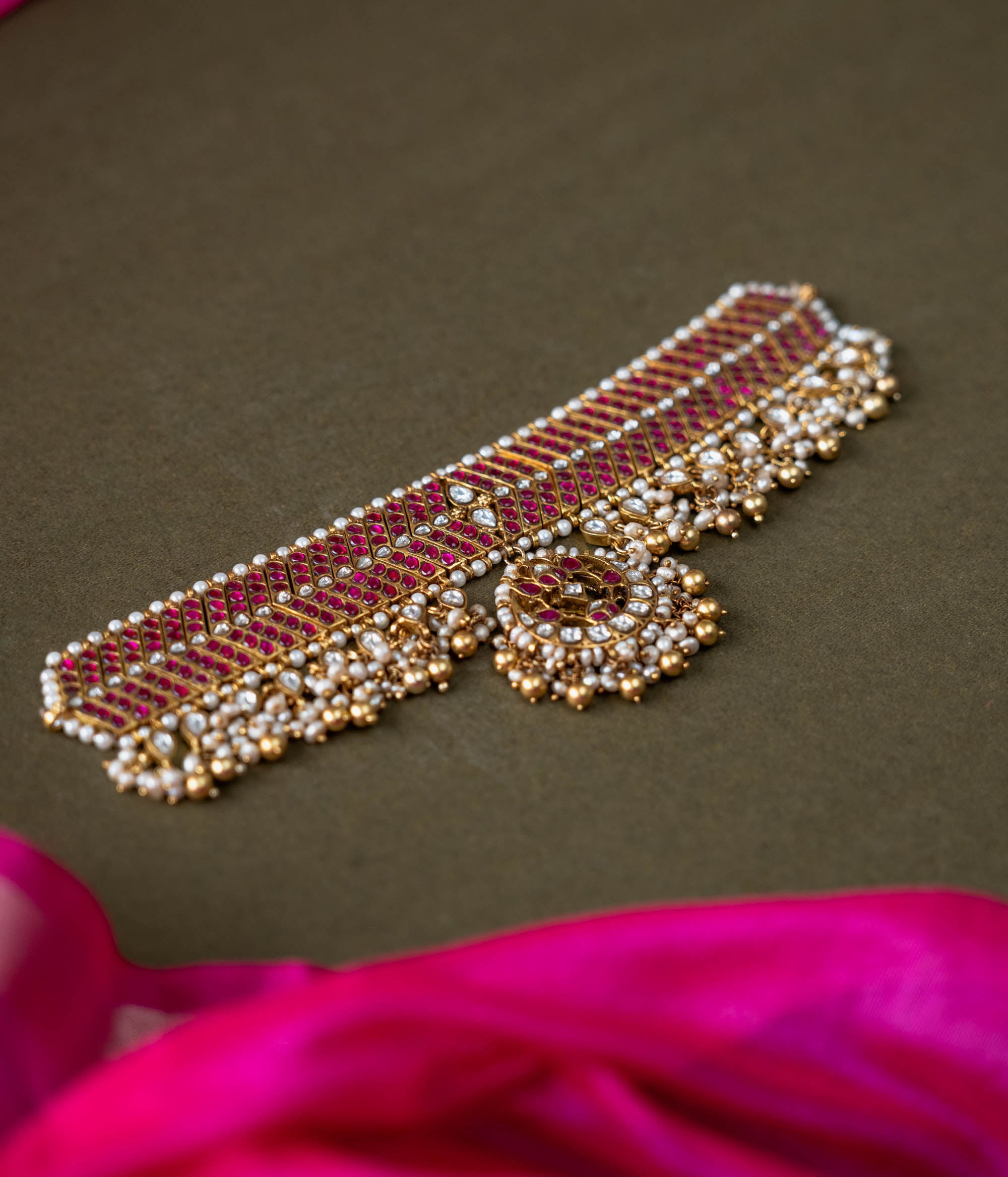 A handcrafted 92.5 sterling silver choker, featuring white and red Kundan stones and pearls, showcasing intricate Kundan detailing and embodying the grandeur of royal heritage and timeless elegance.