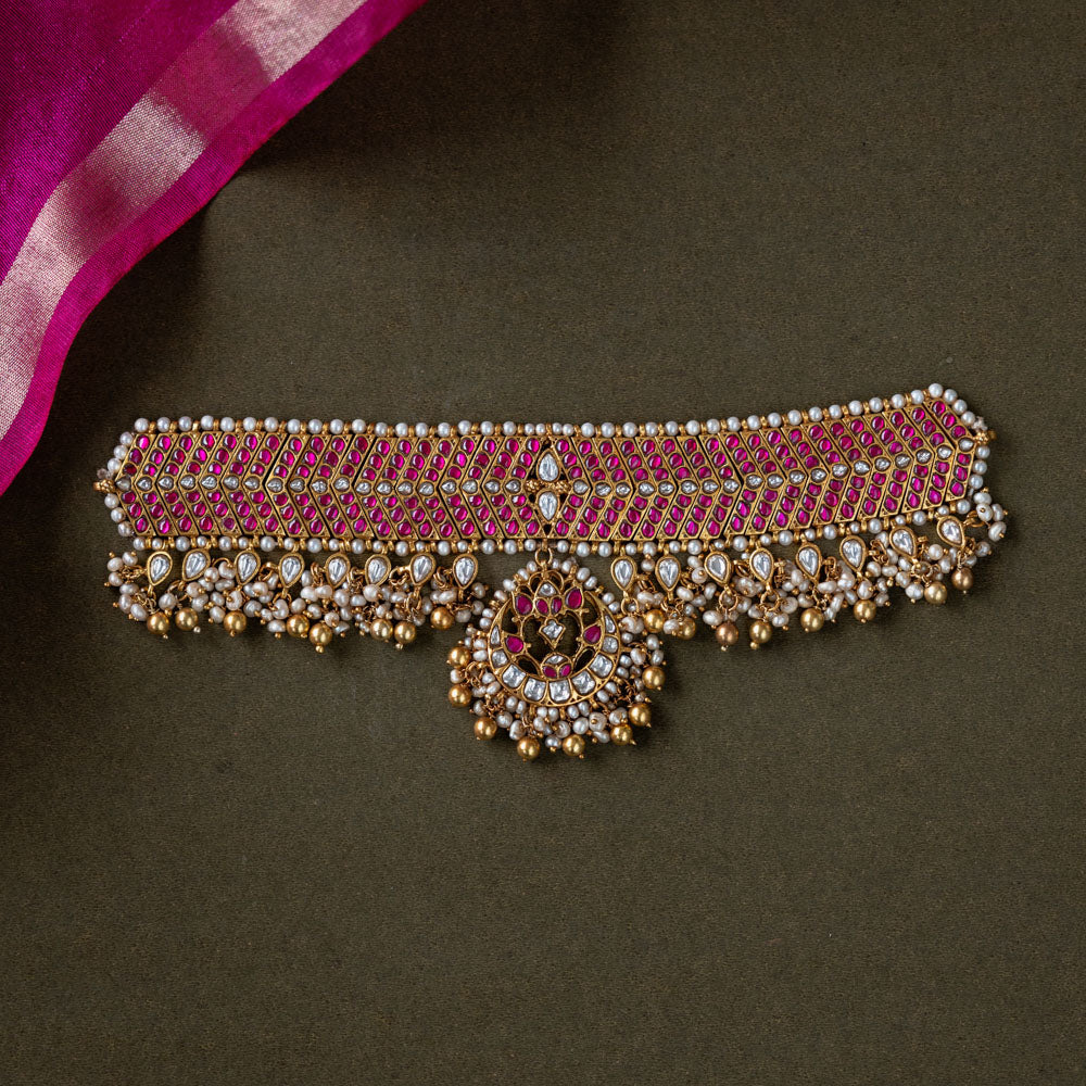 A handcrafted 92.5 sterling silver choker, featuring white and red Kundan stones and pearls, showcasing intricate Kundan detailing and embodying the grandeur of royal heritage and timeless elegance.