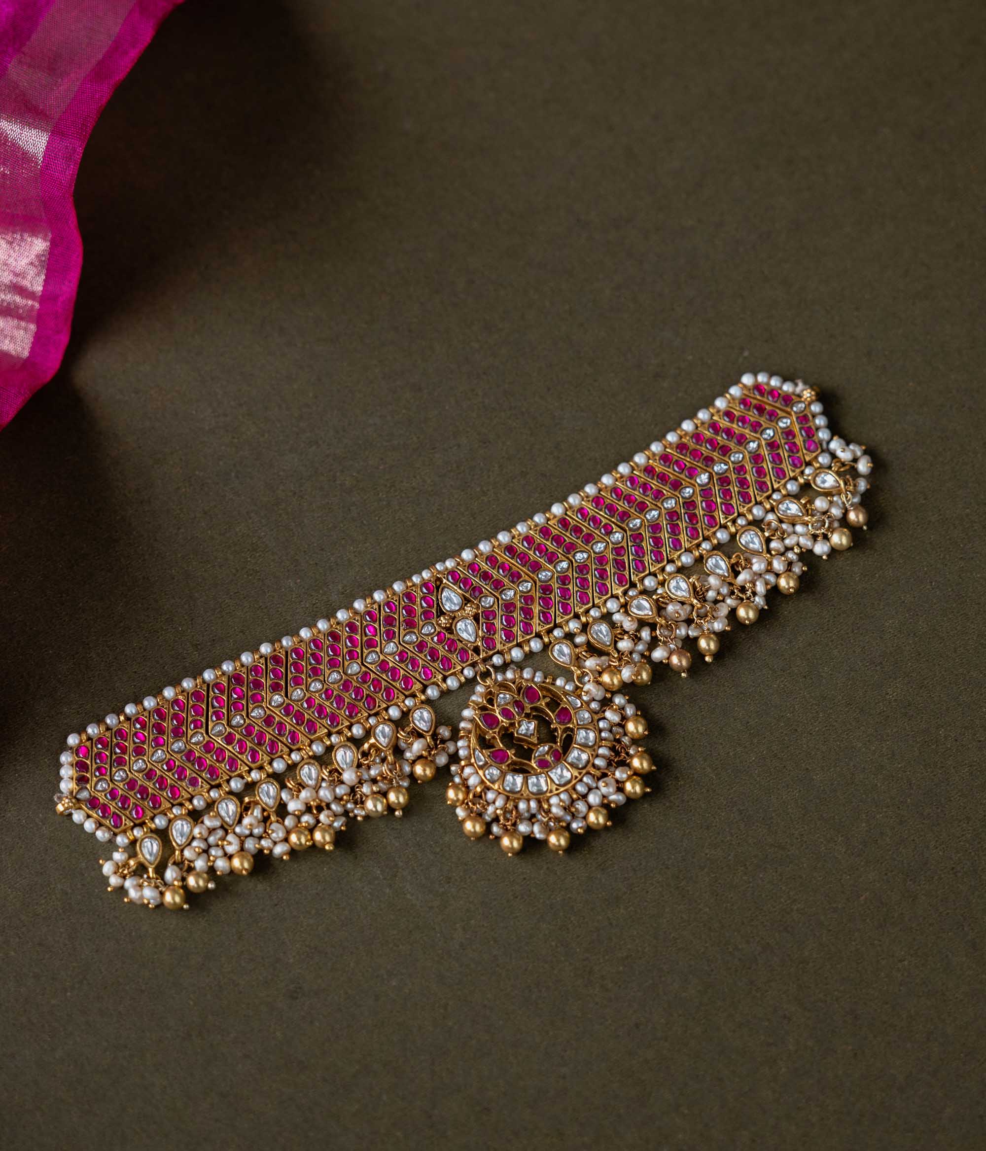A handcrafted 92.5 sterling silver choker, featuring white and red Kundan stones and pearls, showcasing intricate Kundan detailing and embodying the grandeur of royal heritage and timeless elegance.