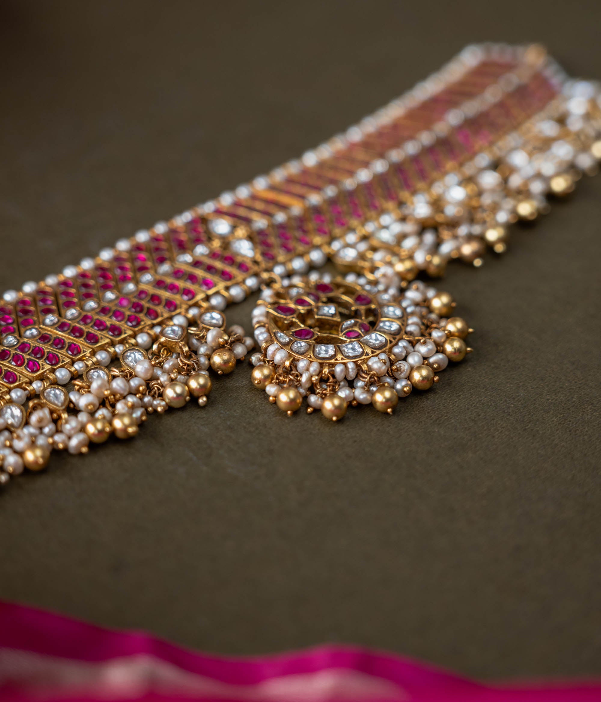 A handcrafted 92.5 sterling silver choker, featuring white and red Kundan stones and pearls, showcasing intricate Kundan detailing and embodying the grandeur of royal heritage and timeless elegance.