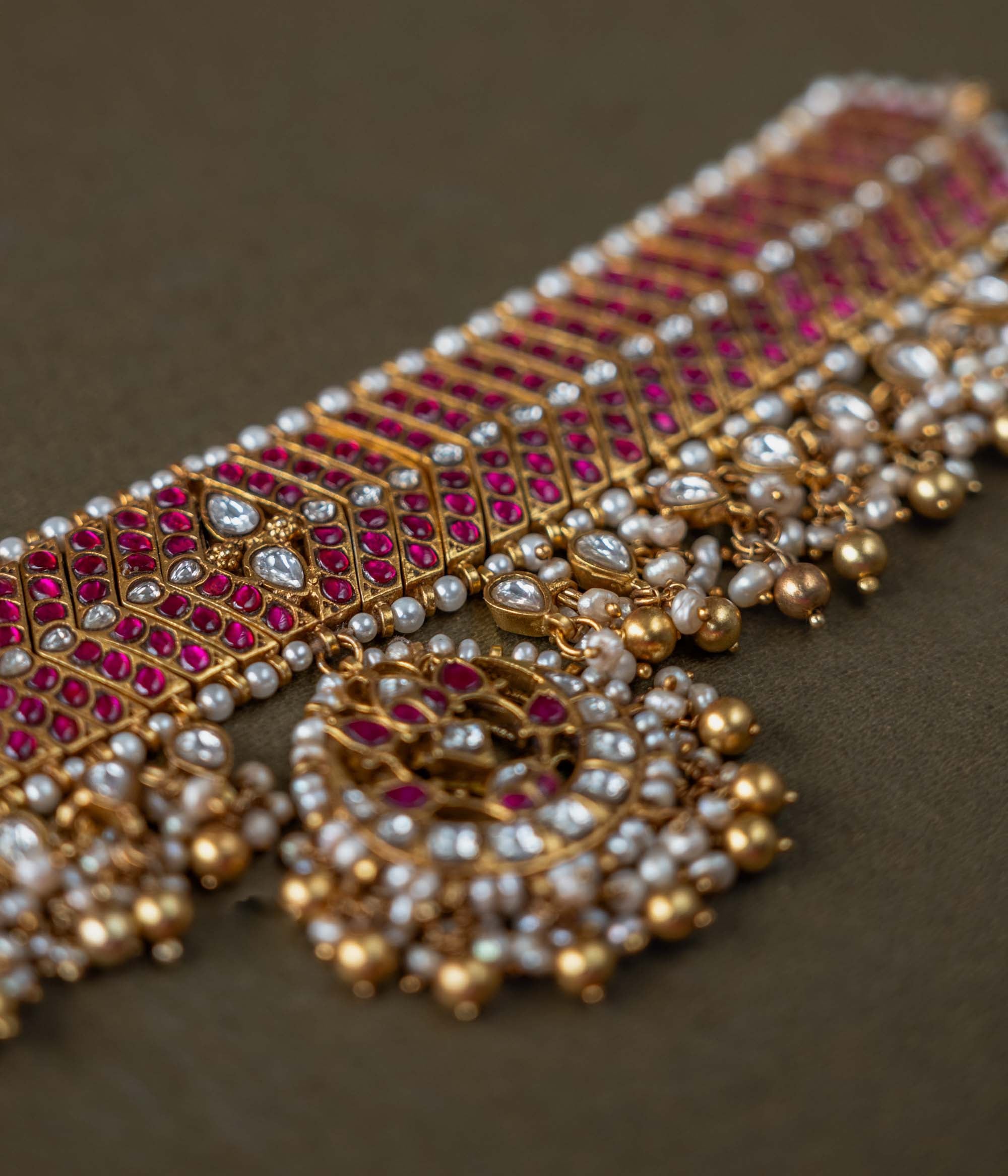 A handcrafted 92.5 sterling silver choker, featuring white and red Kundan stones and pearls, showcasing intricate Kundan detailing and embodying the grandeur of royal heritage and timeless elegance.