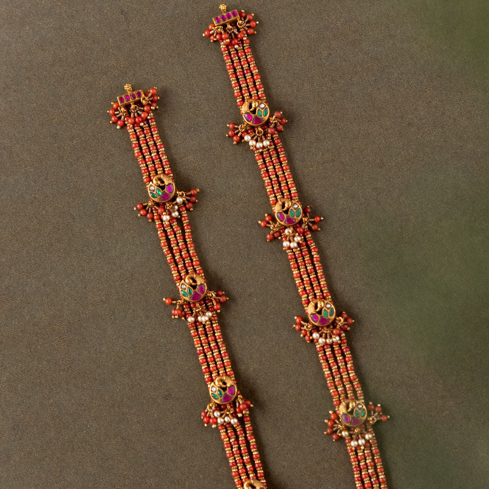 Ranjita Temple Beaded Chain featuring 92.5 sterling silver and 22 carat gold plating. The design includes vibrant coral-hued beads, intricate gold temple-inspired motifs, red, white, and green Kundan stones, and delicate pearls, combining tradition and artistry for a timeless, elegant look.