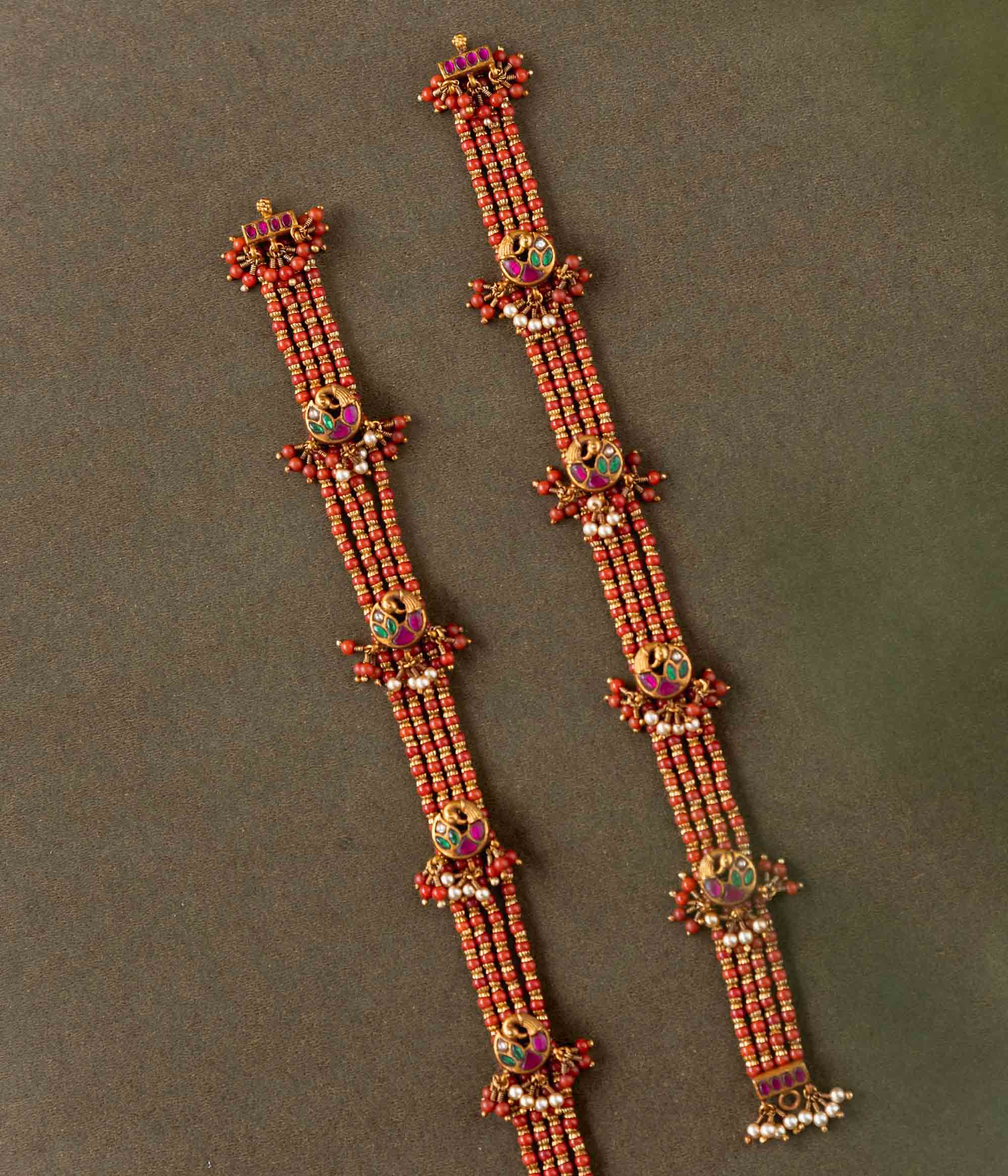 Ranjita Temple Beaded Chain featuring 92.5 sterling silver and 22 carat gold plating. The design includes vibrant coral-hued beads, intricate gold temple-inspired motifs, red, white, and green Kundan stones, and delicate pearls, combining tradition and artistry for a timeless, elegant look.