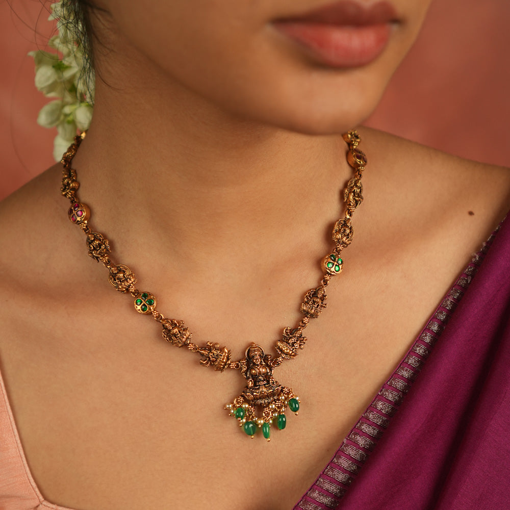 Sacred elegance revived! This antique Lakshmi necklace, crafted in gold-plated silver, radiates prosperity with luminous green Kundan stones and delicate green bead droplets—a timeless tribute to tradition.