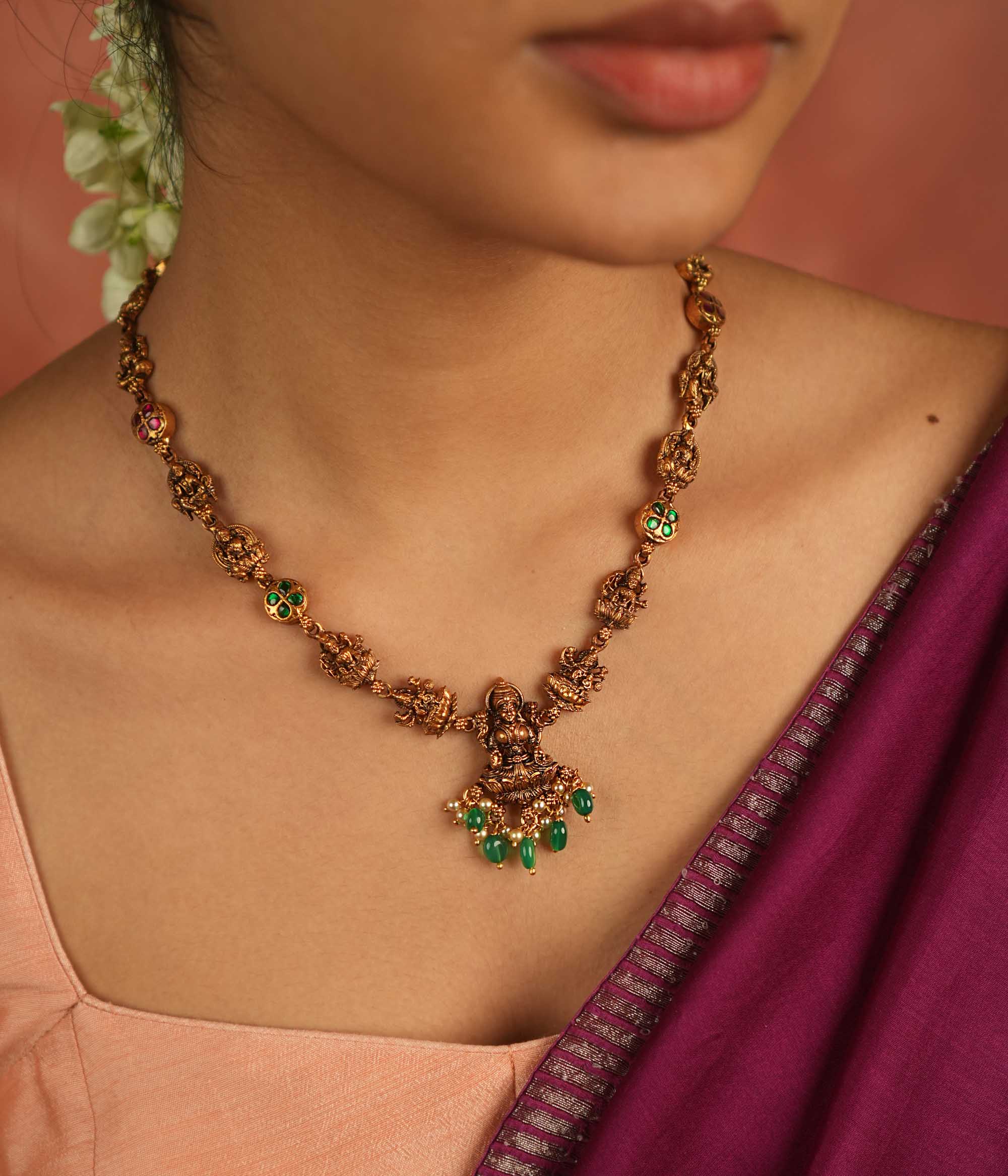 Sacred elegance revived! This antique Lakshmi necklace, crafted in gold-plated silver, radiates prosperity with luminous green Kundan stones and delicate green bead droplets—a timeless tribute to tradition.