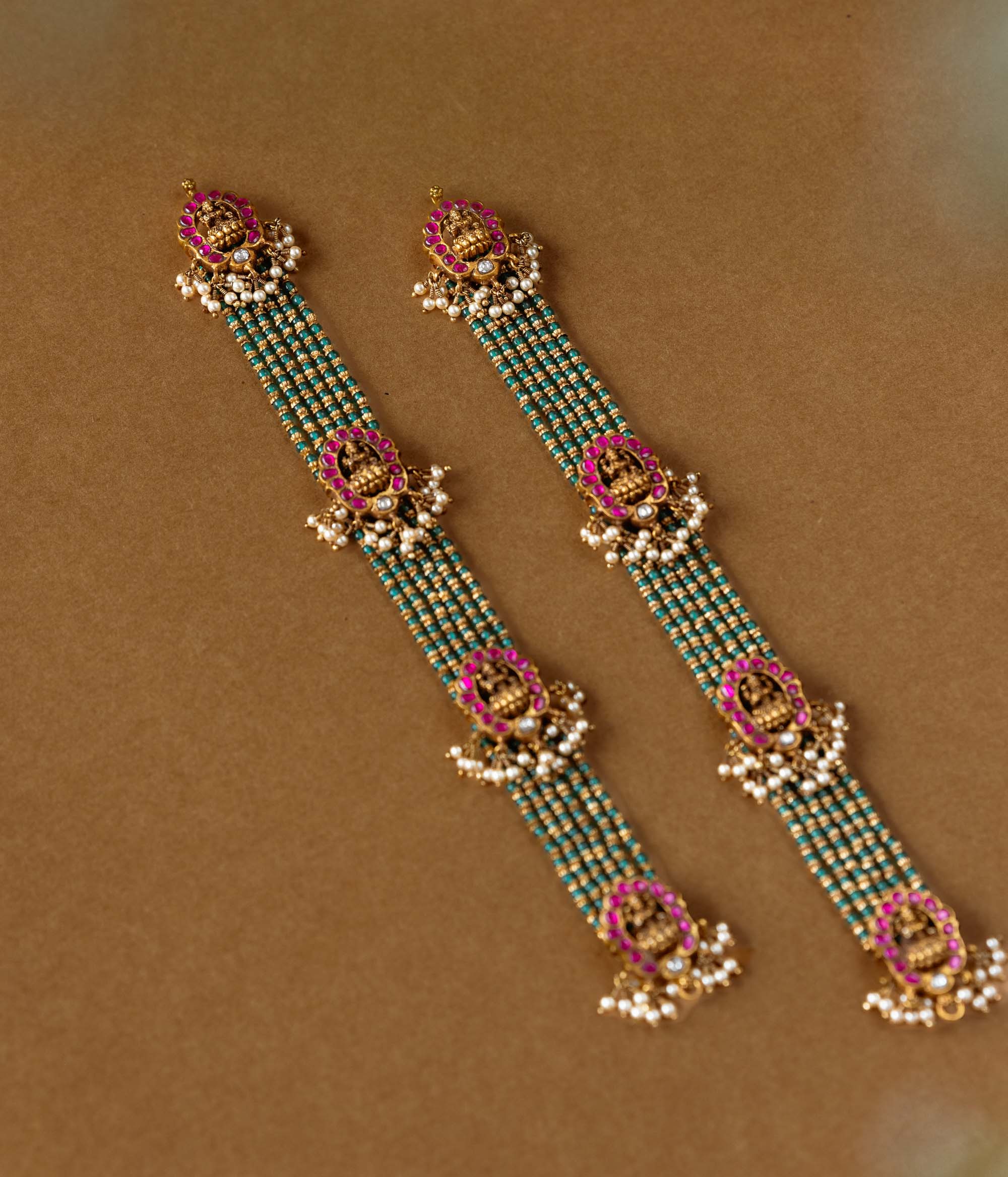 Elegant temple-style beaded chain featuring 92.5 sterling silver, 22k gold plating, red and white Kundan stones, and pearls.