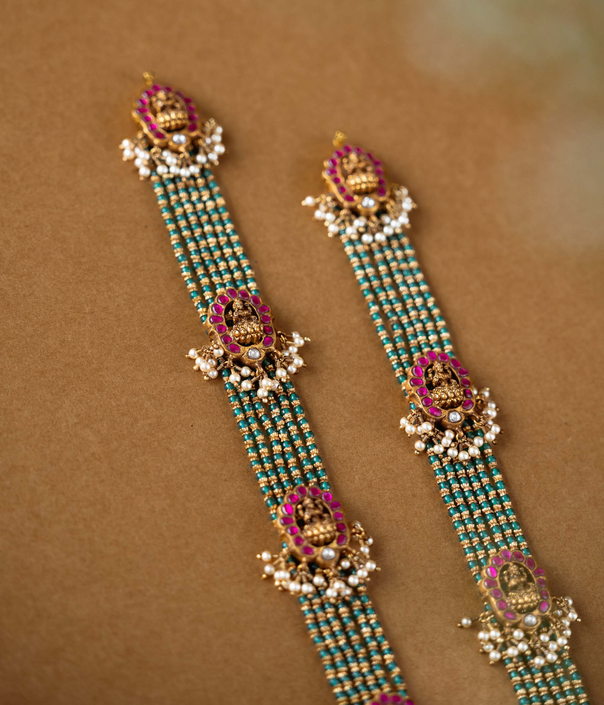 Elegant temple-style beaded chain featuring 92.5 sterling silver, 22k gold plating, red and white Kundan stones, and pearls.