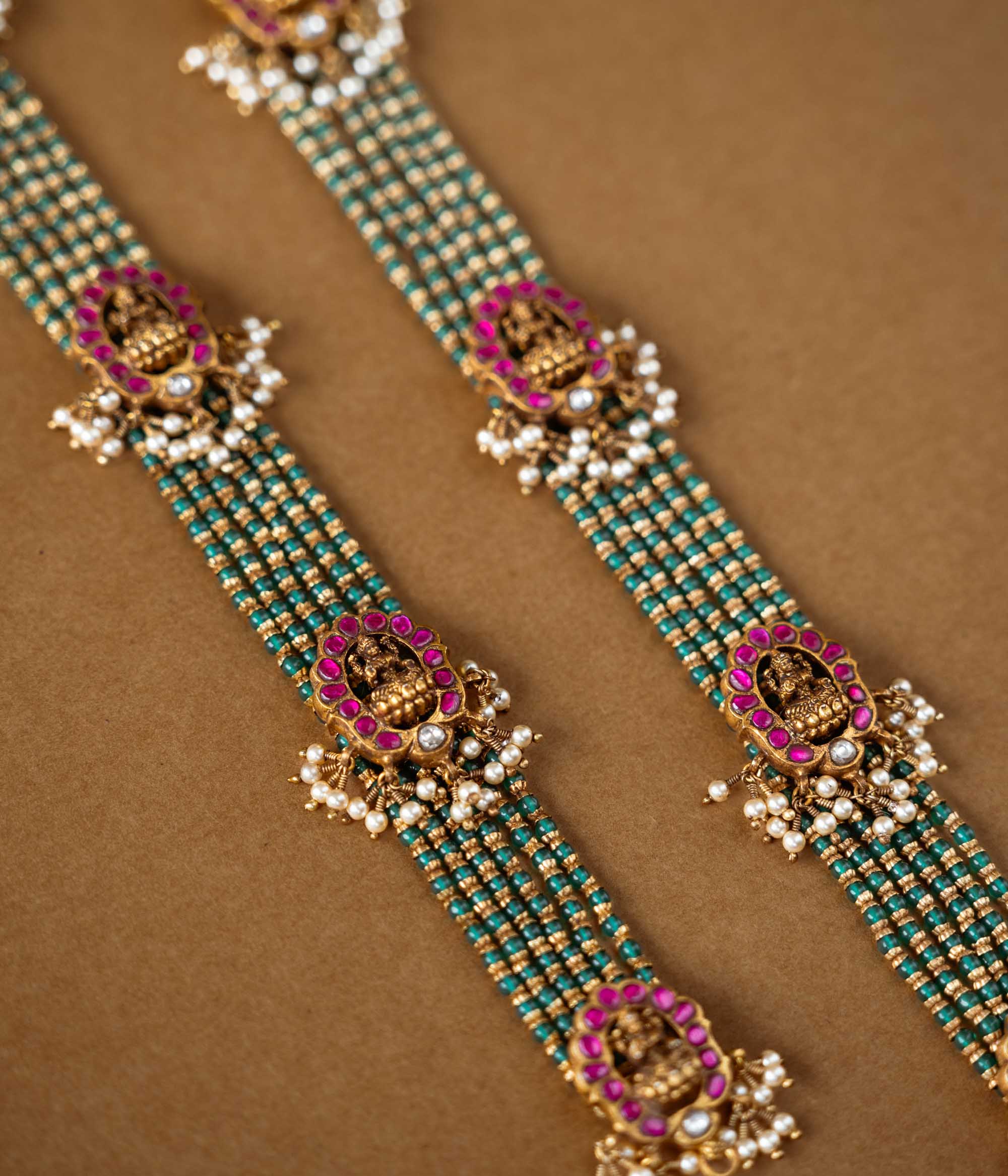 Elegant temple-style beaded chain featuring 92.5 sterling silver, 22k gold plating, red and white Kundan stones, and pearls.
