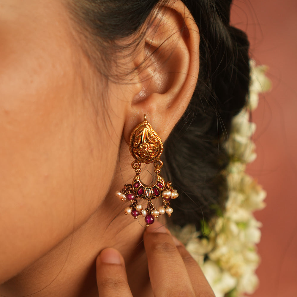 Bazaar whispers reborn! Kundan floral dangler earrings with pearl droplets dance in harmony with vibrant gems, crafting a symphony of elegance.