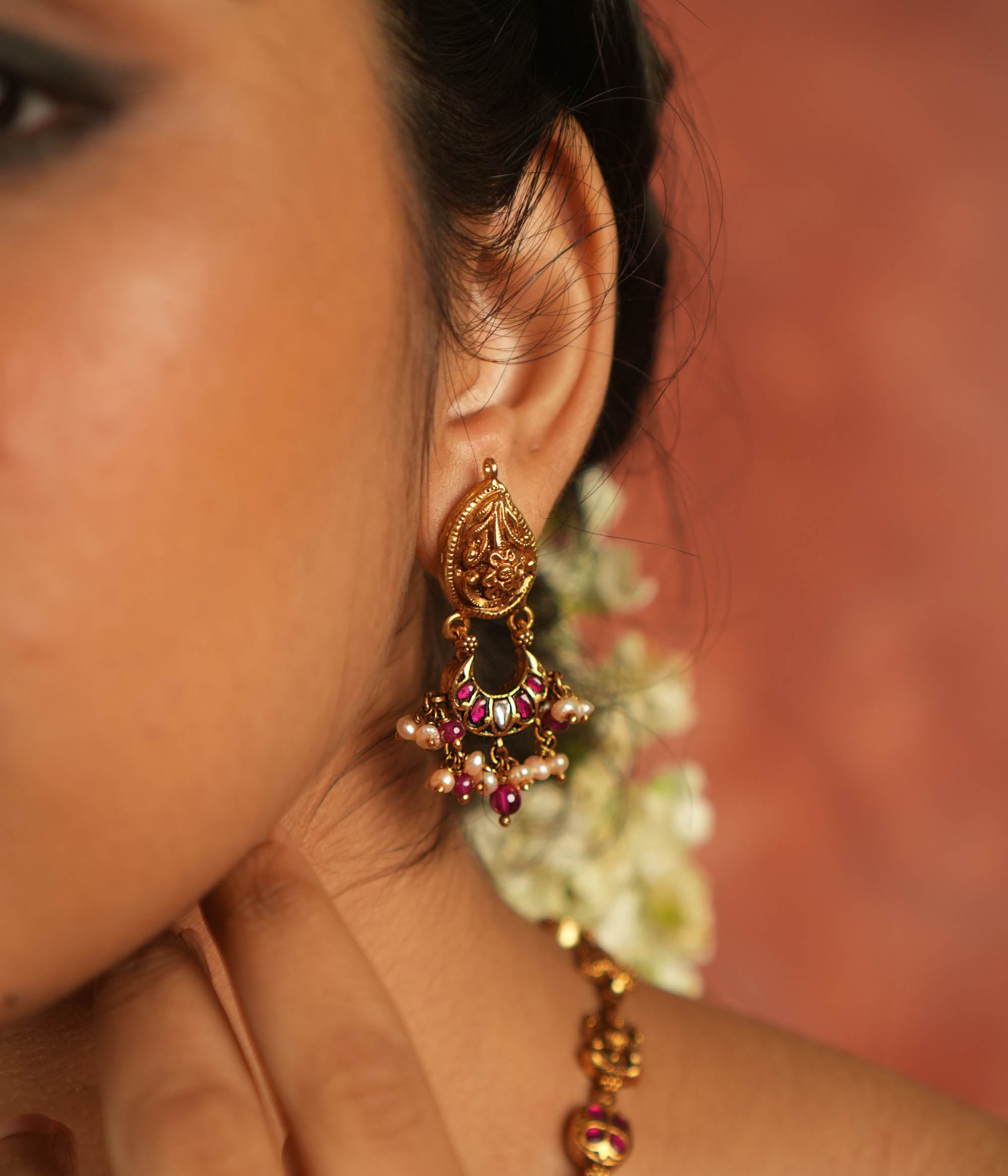 Bazaar whispers reborn! Kundan floral dangler earrings with pearl droplets dance in harmony with vibrant gems, crafting a symphony of elegance.