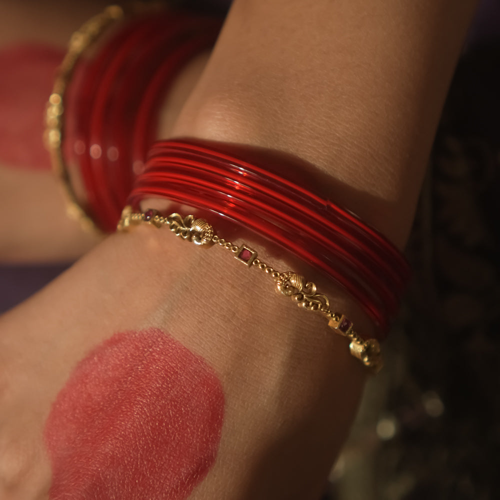 Antique gold-plated silver bangle with crimson threads and links.