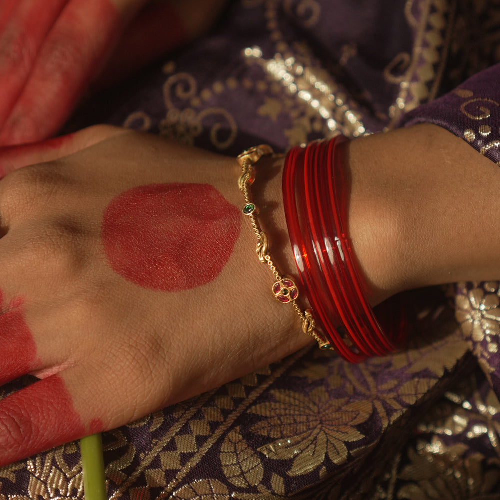 Gold-plated silver bangle with scattered gemstones.